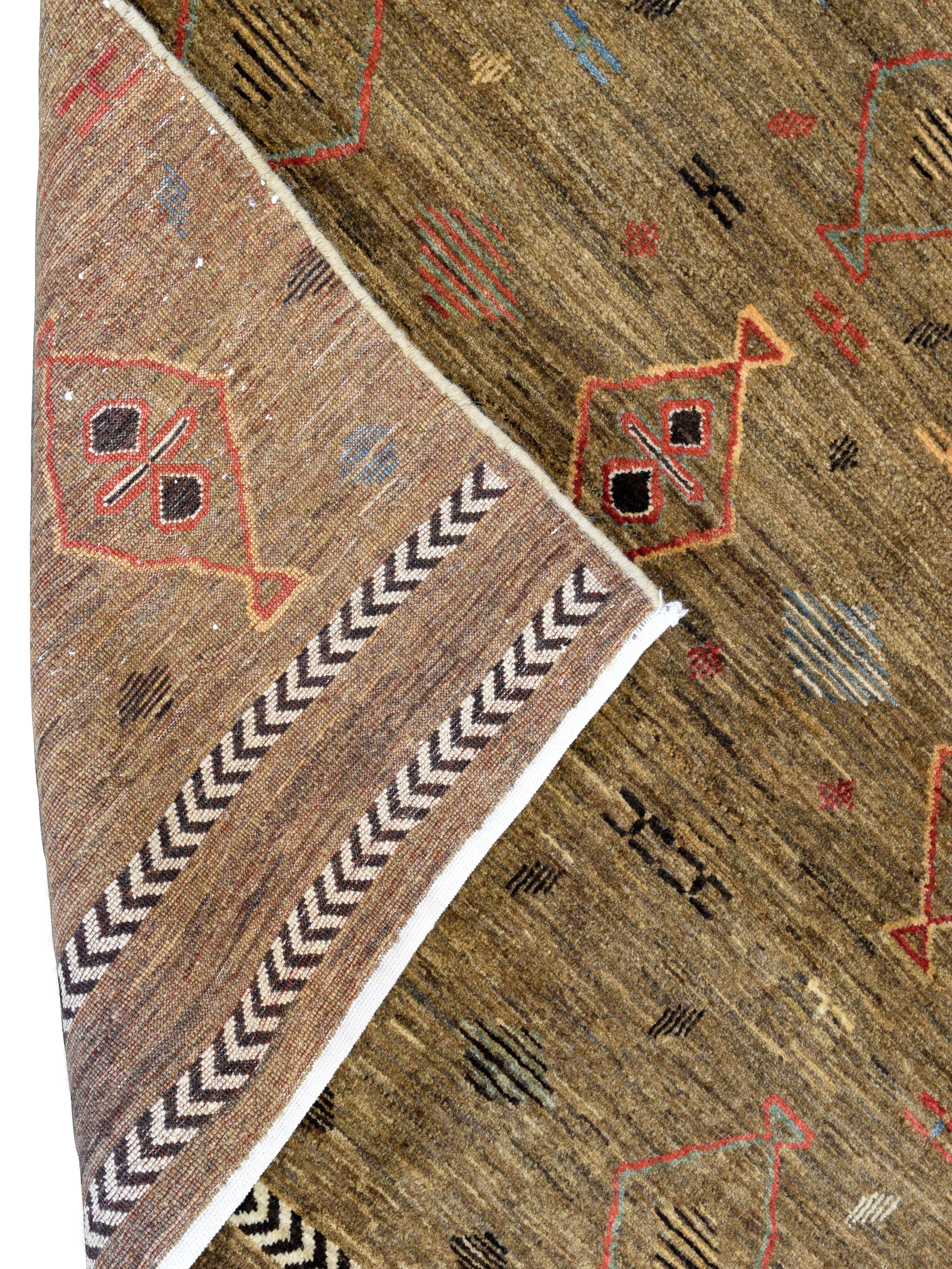 Radicato nella tradizione e ricco di carattere, questo tappeto in lana annodato a mano di 4' x 6' presenta un motivo geometrico di ispirazione tribale in marrone, ruggine e indaco. Il motivo rende omaggio ai linguaggi intrecciati degli artigiani