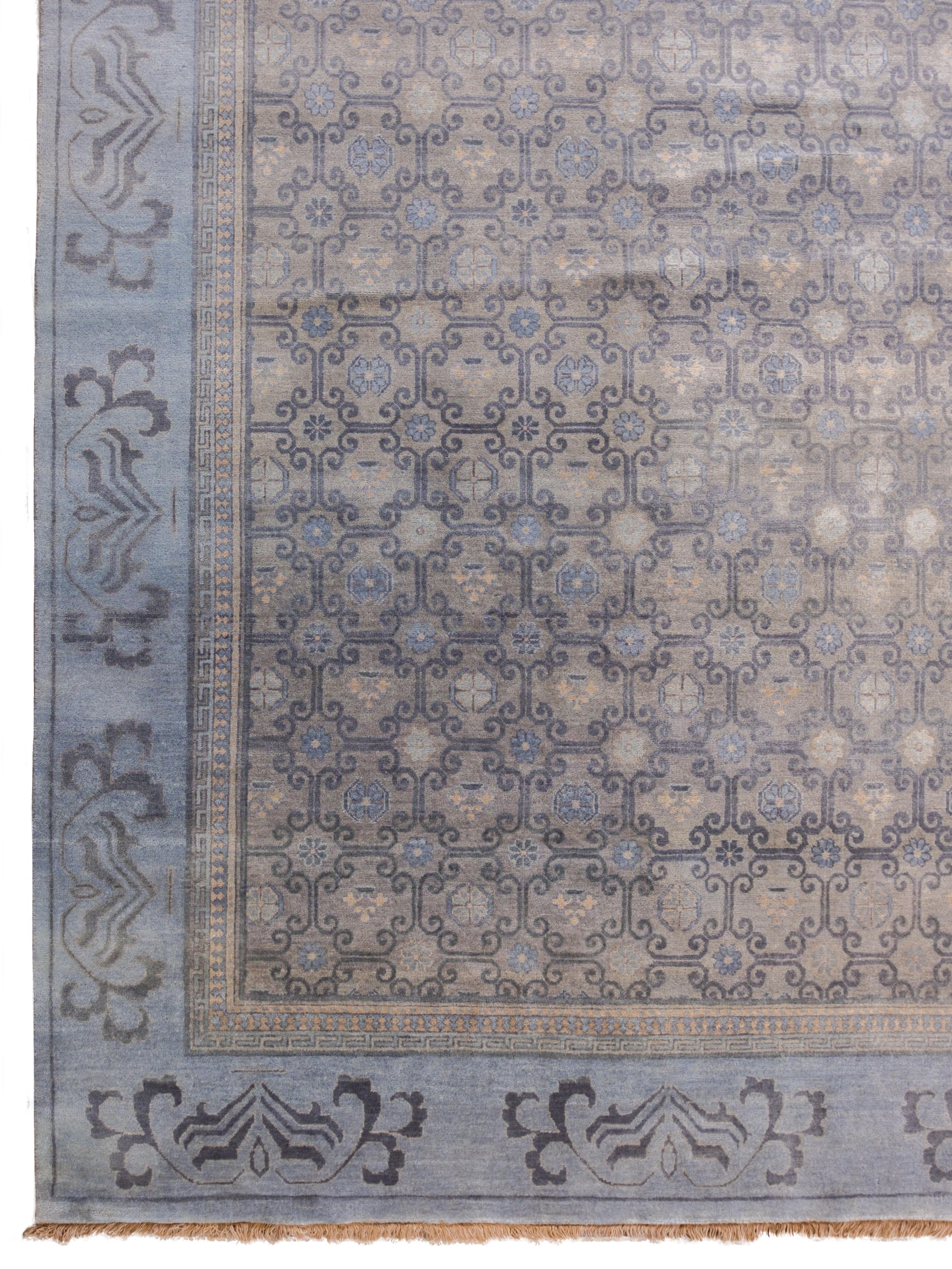 Hand-knotted in versatile shades of gray, taupe, cream, and steel blue wool, this transitional Persian Khotan carpet measures 9' x 12' and belongs to the Orley Shabahang World Market Collection. Like all traditional Persian Khotan carpets, this