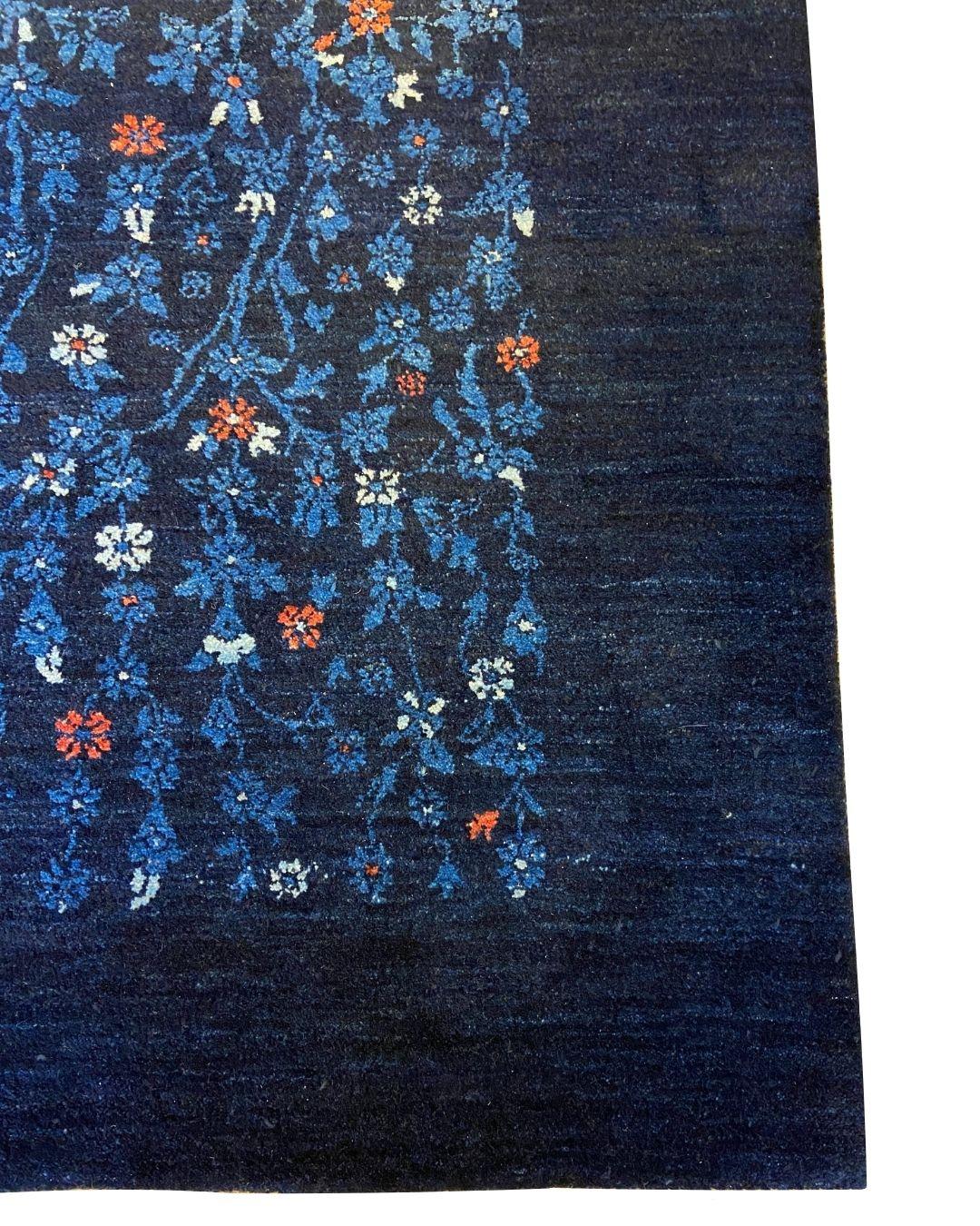 Dieser handgeknüpfte Perserteppich aus indigoblauer Wolle mit komplizierten Blumenmotiven in den Maßen 6' x 9' ist ein atemberaubendes Zeugnis der zeitlosen Raffinesse der persischen Handwerkskunst. Das tief indigoblaue Feld ist mit einer Symphonie