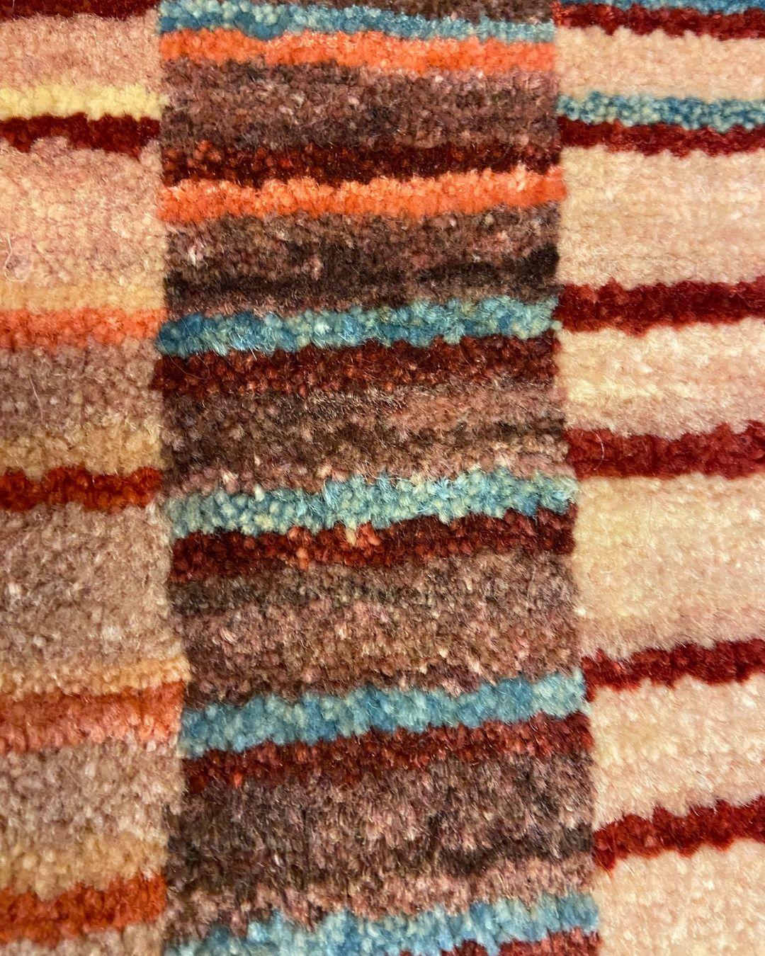 Dieser 8′ × 10′ große handgeknüpfte Teppich aus persischer Wolle aus der Modern Collection'S von Orley Shabahang ist eine kunstvolle Ode an das Design der Jahrhundertmitte. Sein wellenförmiges, lineares Motiv - bestehend aus gestapelten rechteckigen