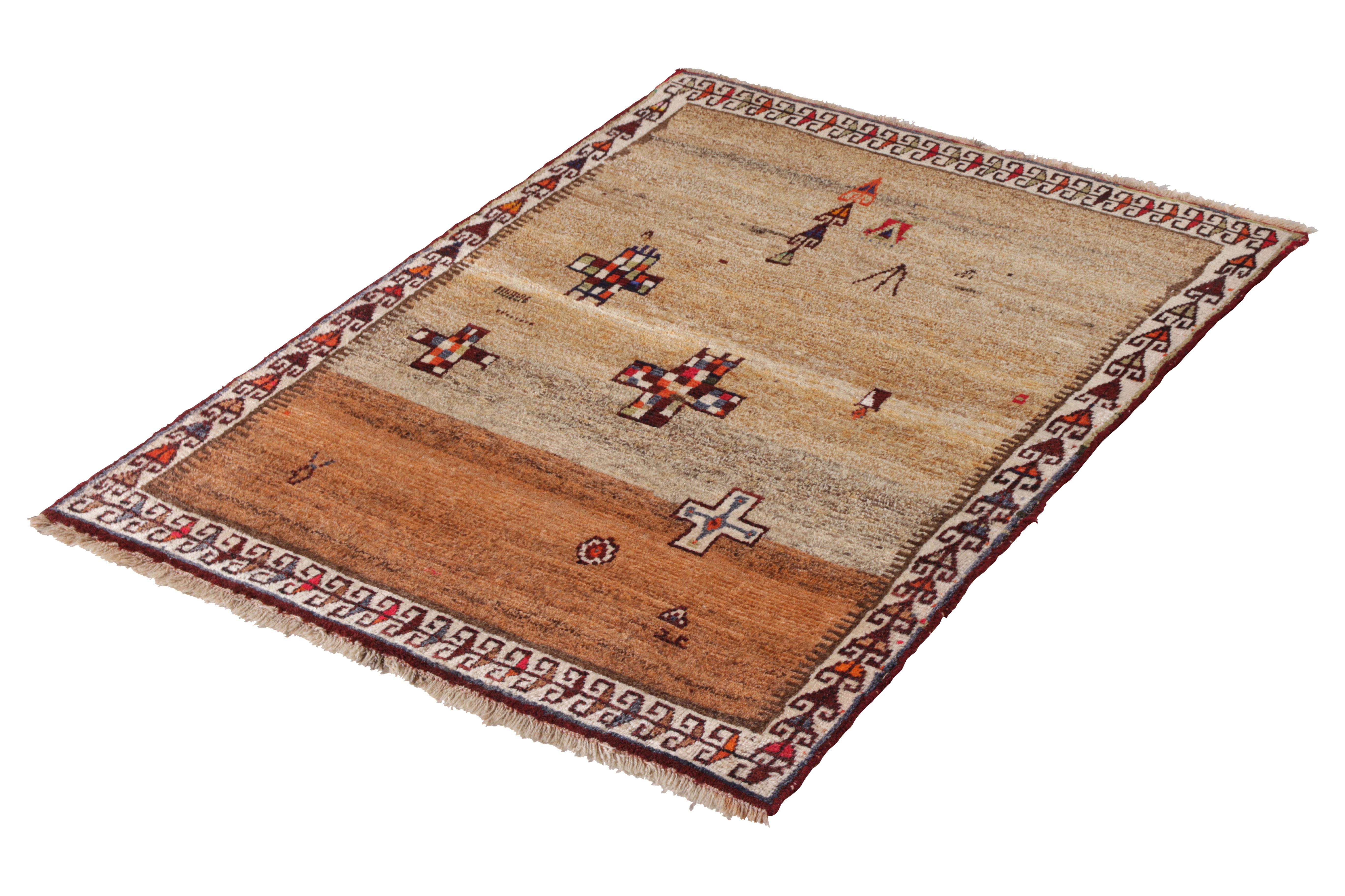 Hand knotted in wool originating circa 1950-1960, this vintage Persian rug connotes a mid-century Persian rug design with a unique juxtaposition of traditional and uncommonly Minimalist tribal elements, a primitivism array of cross motifs against a