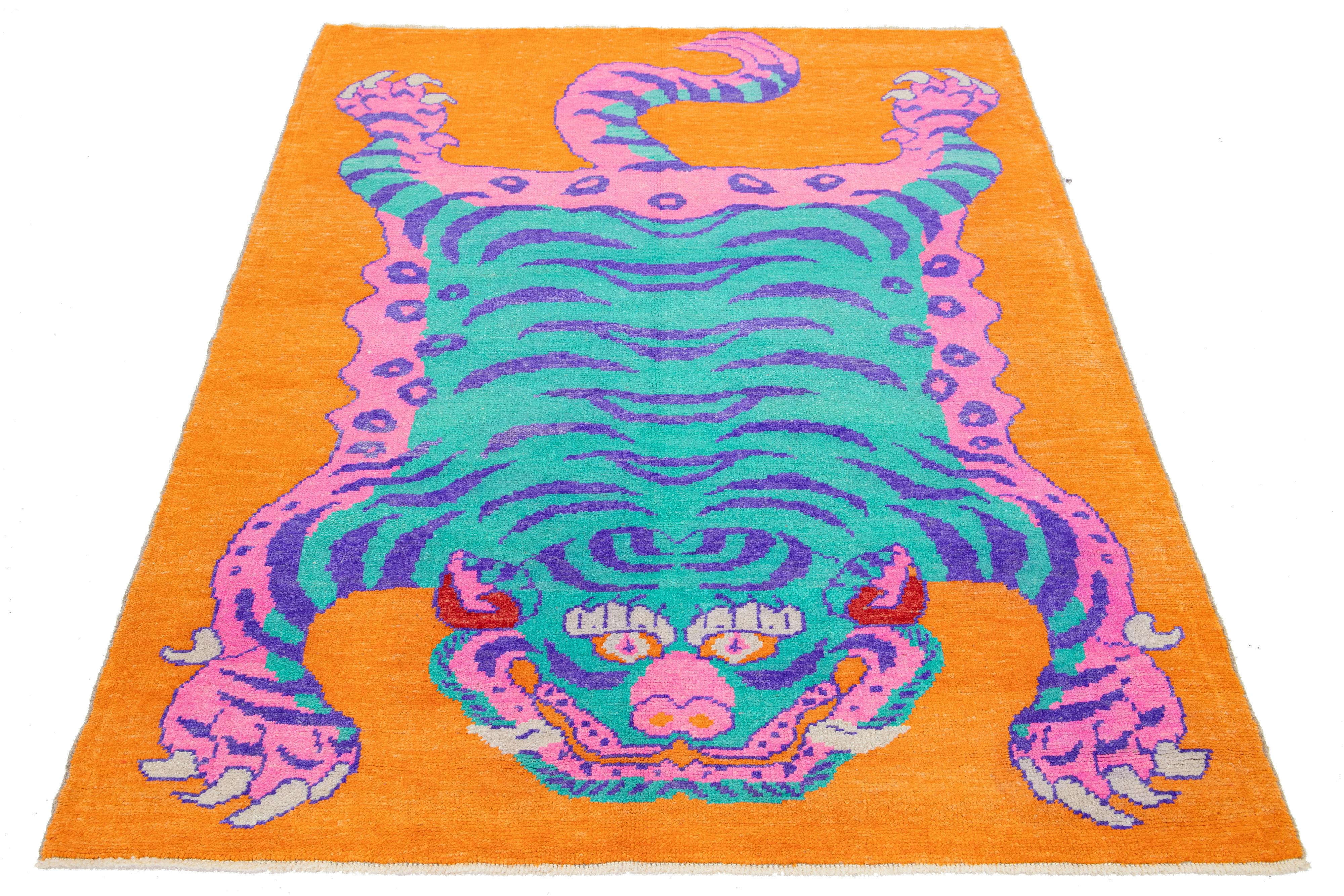 This is a beautiful handmade Turkish Art Deco wool rug with an orange field and blue, pink, and purple accent colors in a gorgeous tiger pictorial design. 

This rug measures 5'5