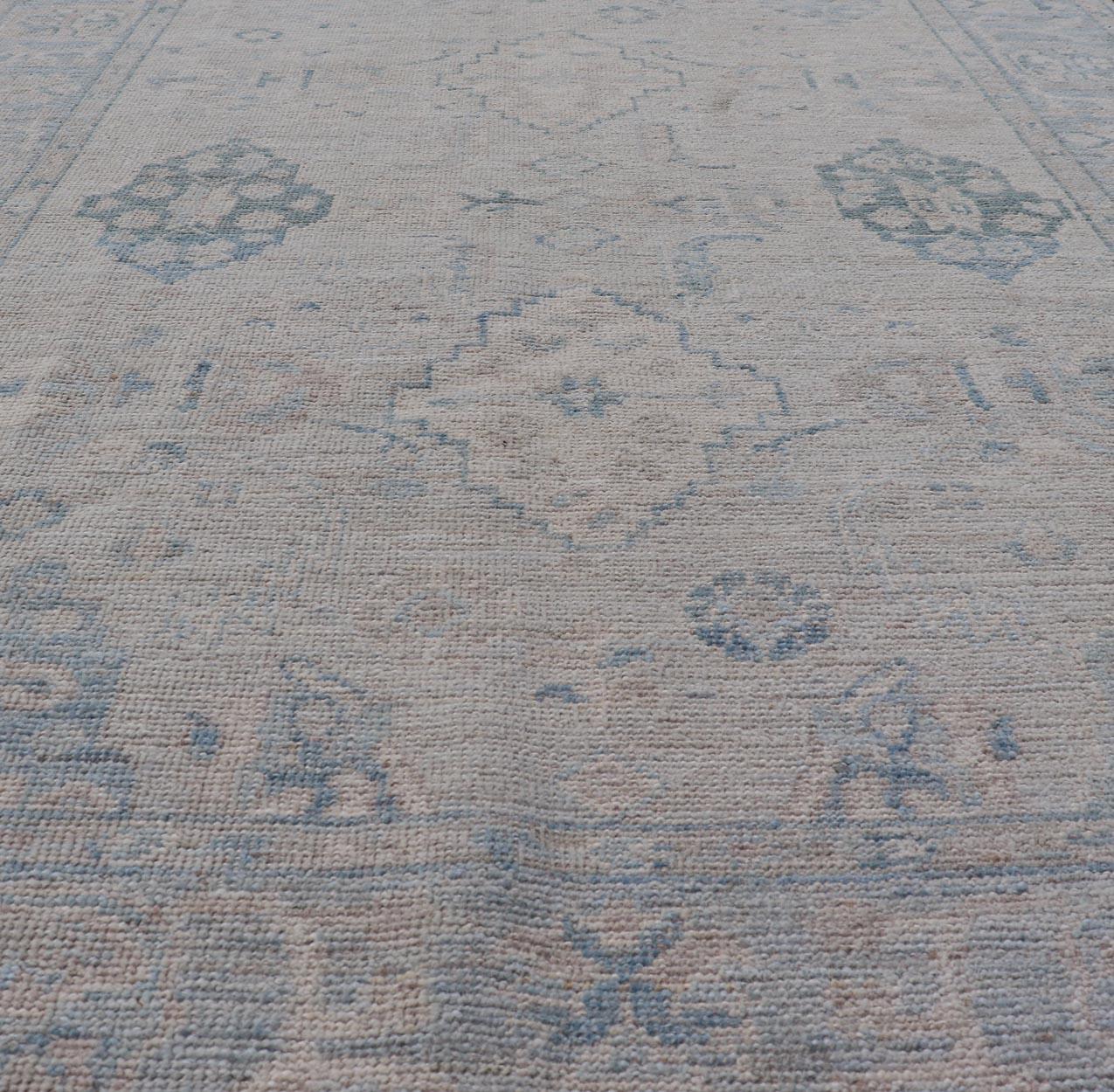 Afghan Hand-Knotted Oushak with a Light Blue Background and Tribal Motifs For Sale