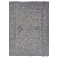 Hand-Knotted Oushak with a Light Blue Background and Tribal Motifs