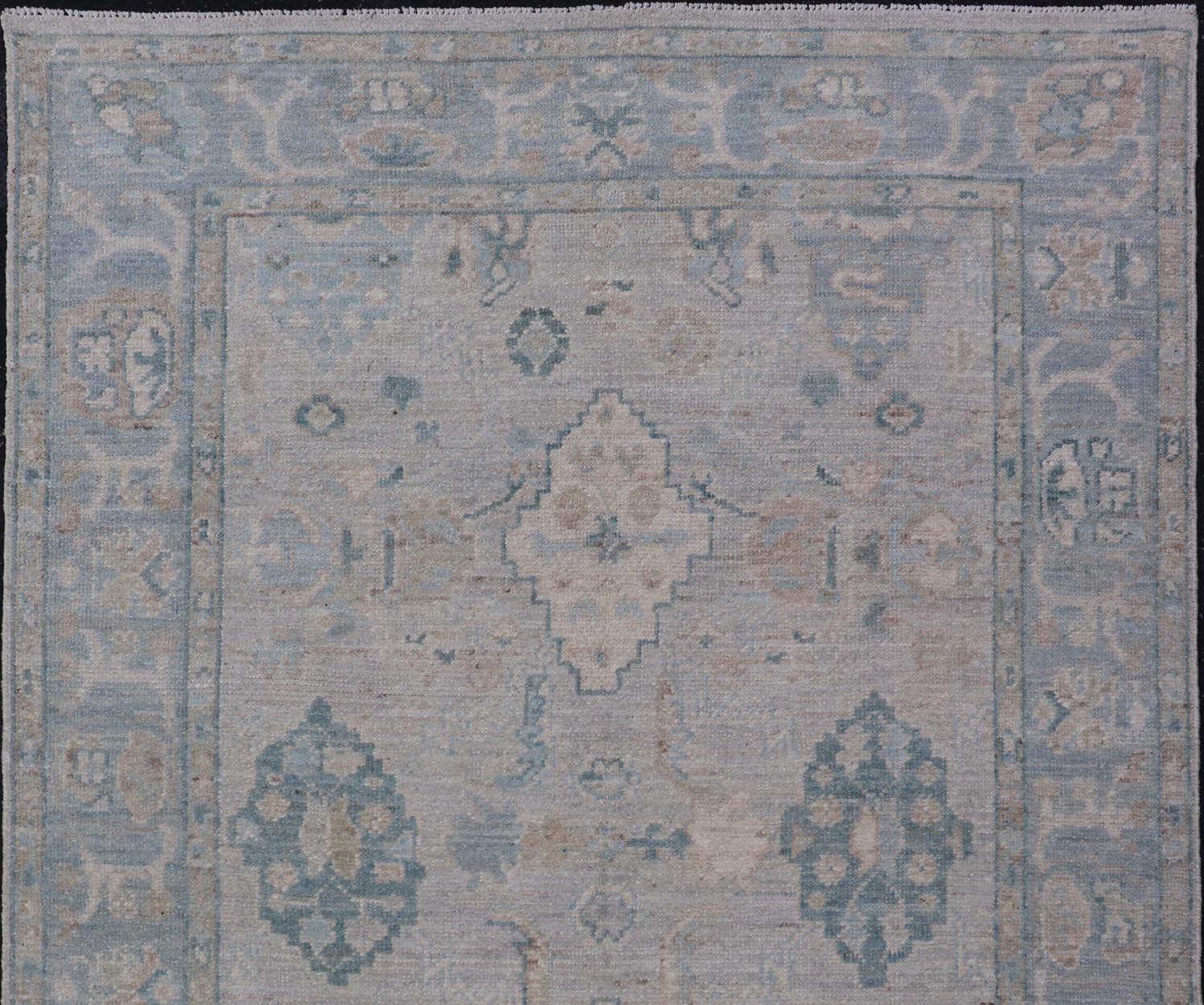 Contemporary Hand-Knotted Oushak with a Light Blue-Gray Background and Tribal Motifs For Sale