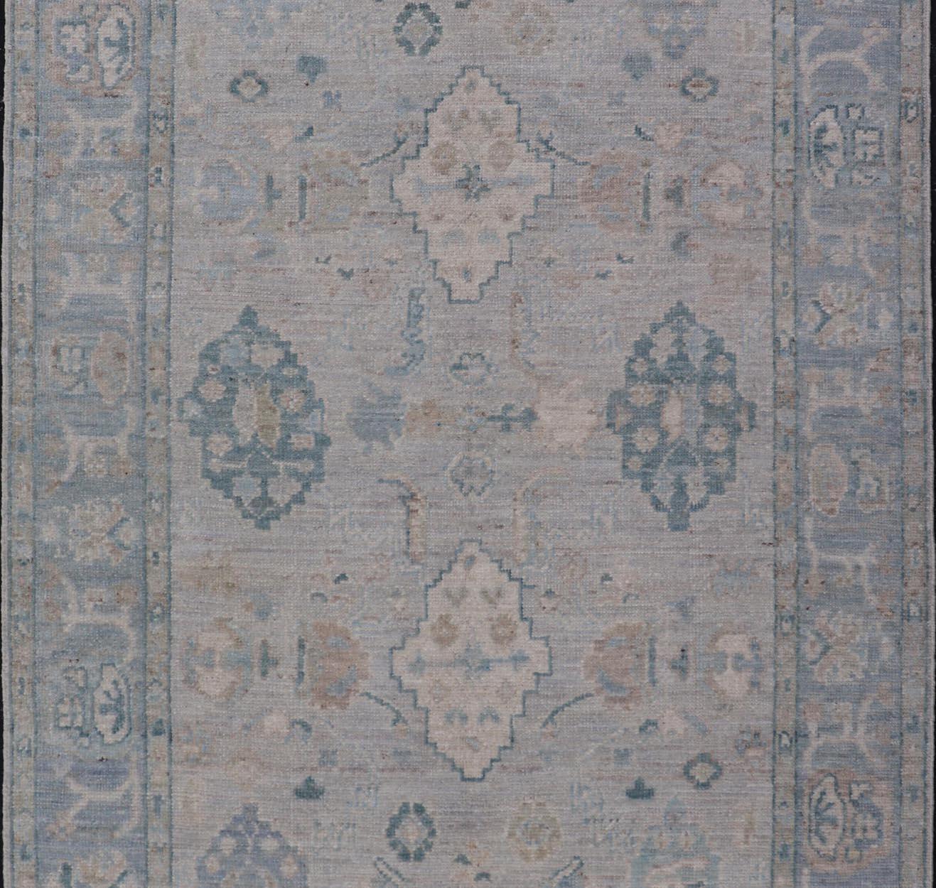 Wool Hand-Knotted Oushak with a Light Blue-Gray Background and Tribal Motifs For Sale