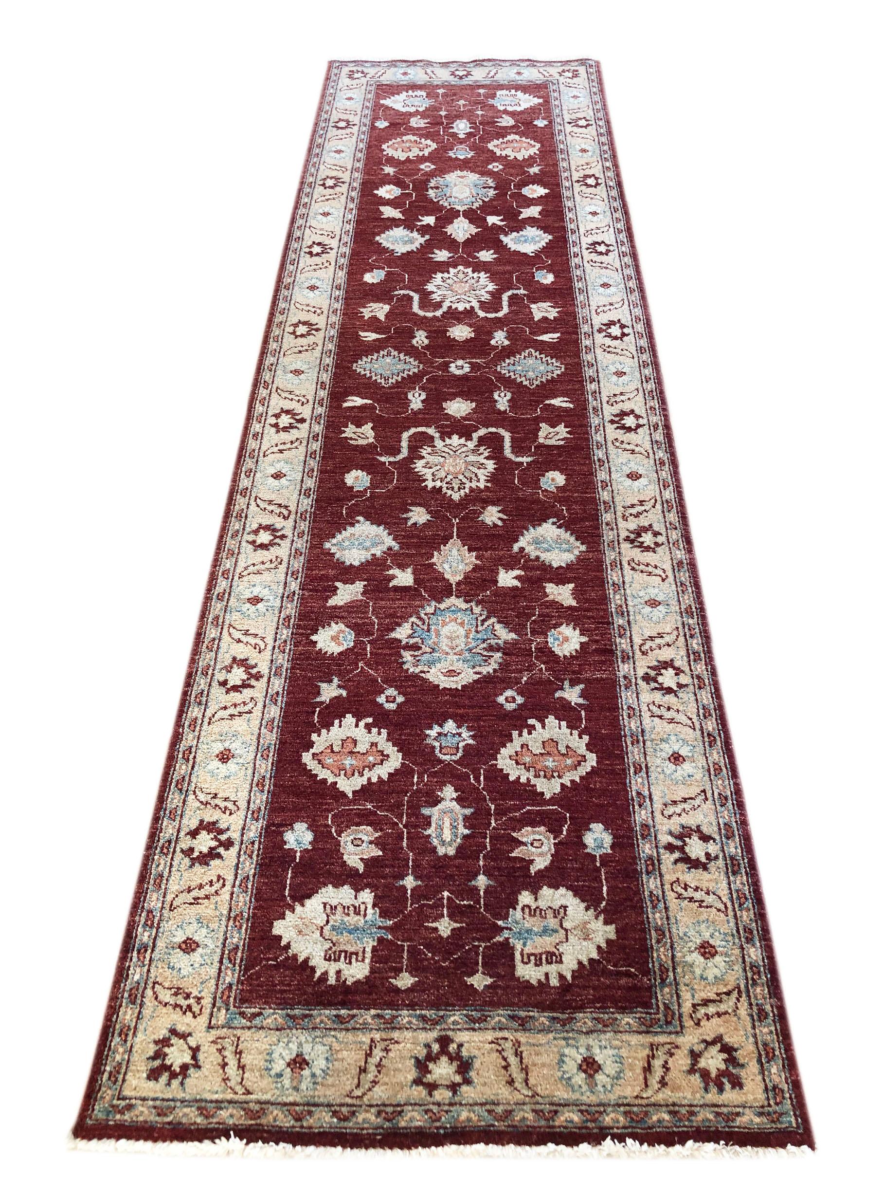 This Peshawar Pakistan rug is a fine knotted with a wool pile and cotton weft. The base color is burgundy and the border is cream. The Peshawar rugs are in high demand across the market because their design, quality and color combination. The size