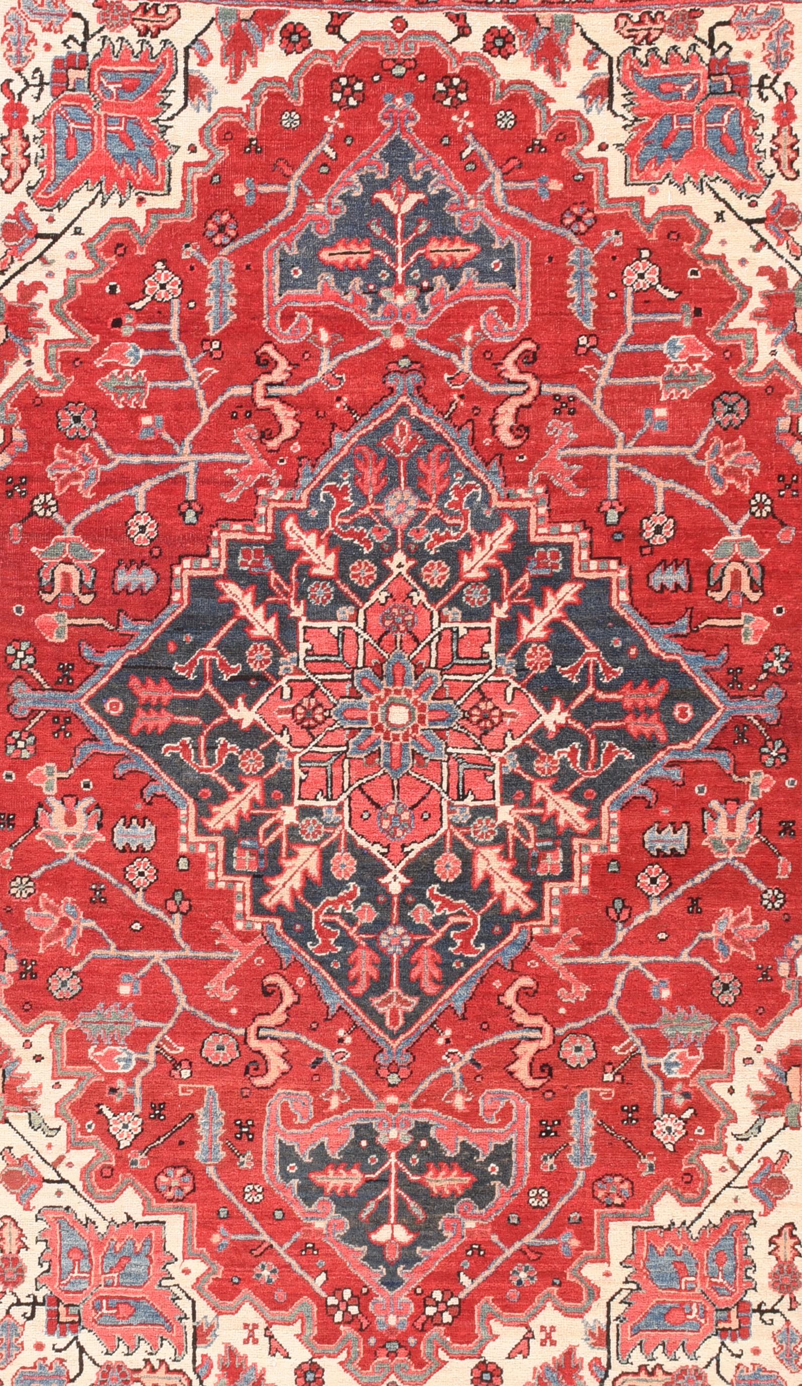 Looks like a room size, but this uncommon scatter format NW Persian village scatter shows a vivid natural dye palette with a tomato madder red field centred by a partially stepped navy fiamond medallion filled with serrated, radiating leaves and a