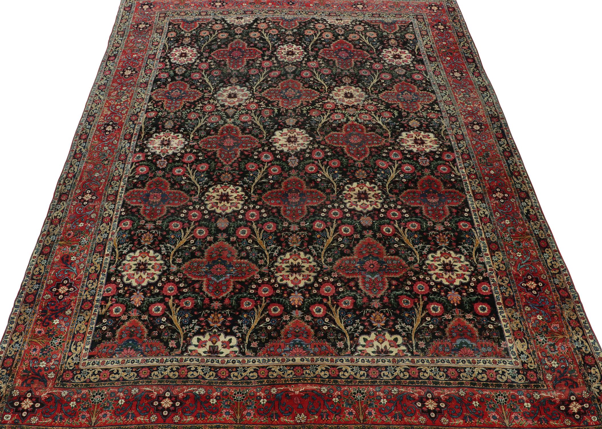 An antique 10x15 Persian rug from Tehran, hand-knotted in wool circa 1920s.

Further On the Design:

This antique piece is a royal selection that enjoys an all over floral design in blue, red and off-white on a bold black field. Keen eyes will