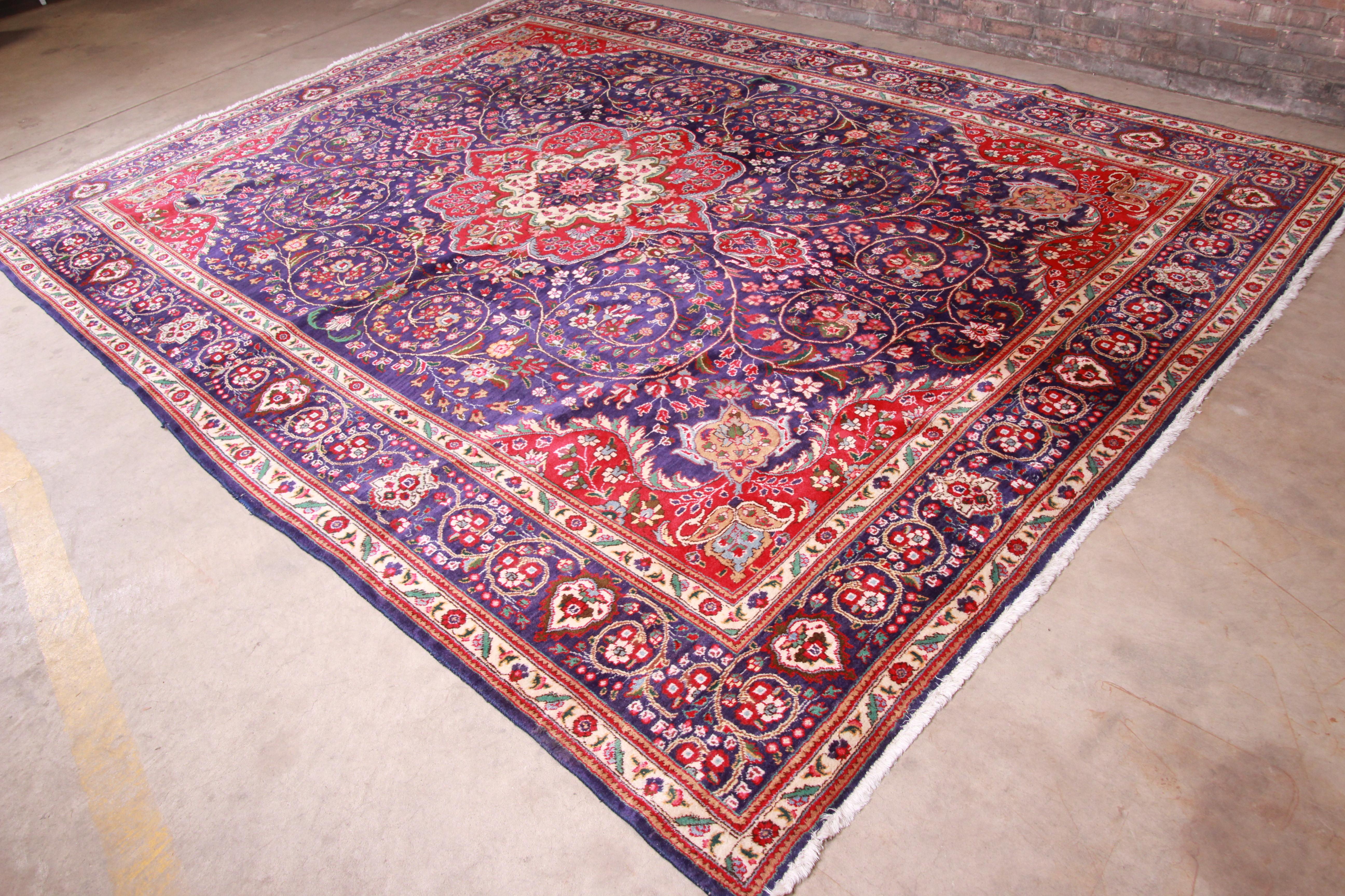 A gorgeous vintage hand knotted Persian Tabriz wool area rug

Late 20th century

Classic design with floral sprays and bouquets in a rich royal blue field with red, green, cream, and pink accents.

Measures: 9