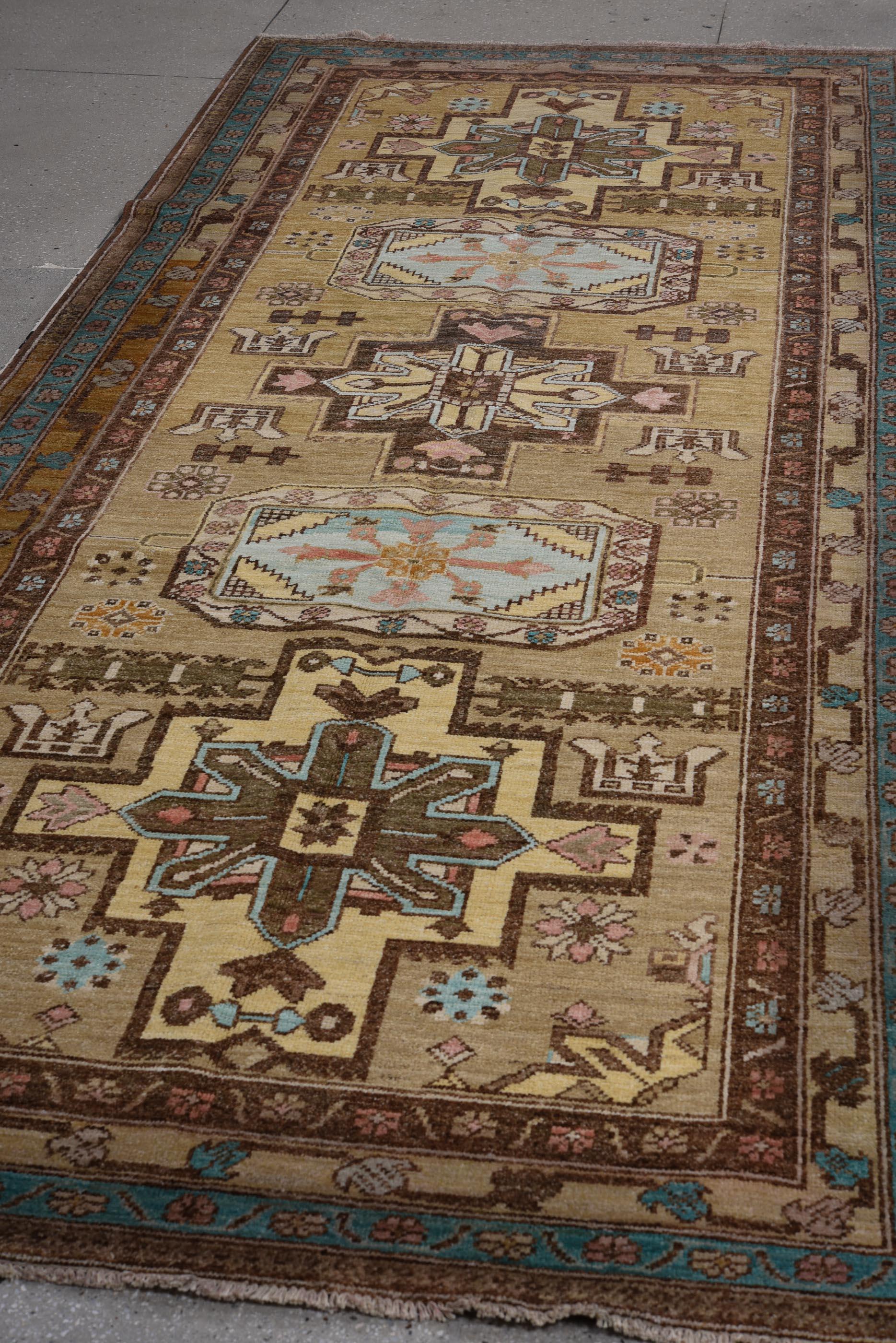 Esta alfombra Sarab vintage anudada a mano, procedente del noroeste de Persia, presenta una majestuosa serie de medallones tribales a gran escala en suaves tonos inspirados en el desierto. Un campo en tonos de trigo proporciona un cálido telón de
