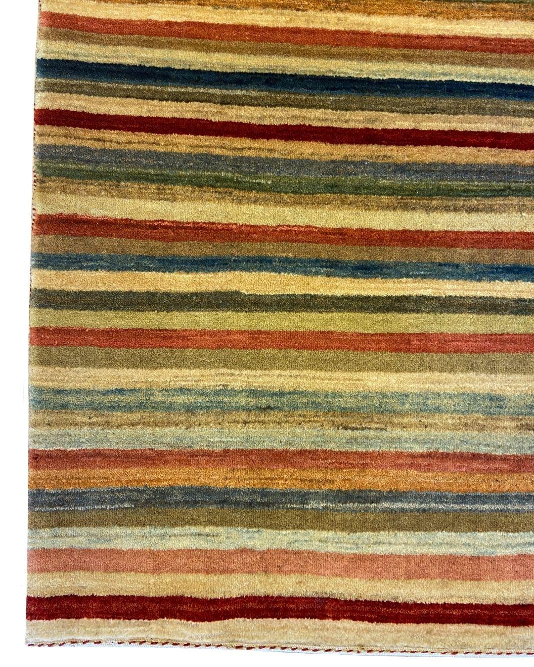 Dieser handgeknüpfte 3' x 5' Shekarloo Wollteppich mit mehrfarbigen Streifen verwandelt die traditionelle persische Weberei in einen modernen visuellen Rhythmus. Dieser Teppich wird in präziser Handarbeit aus organischer, handgesponnener Wolle