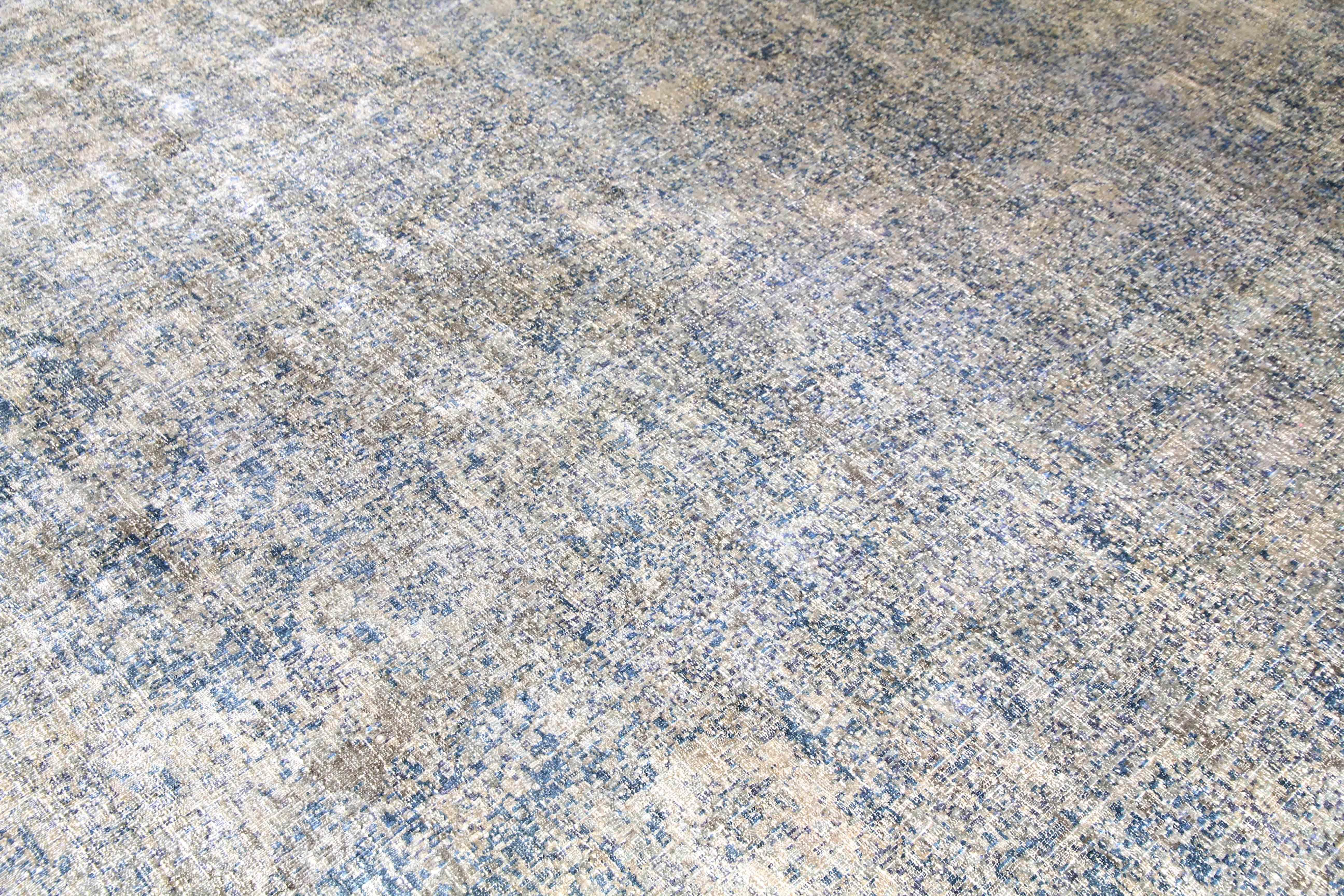 This hand-knotted rug is an exhibit of an exceptionally reductive method that harnesses the natural texture of color to bring out hidden tonalities and textures underneath the foundation of the rug. A distressed finish is revealed with