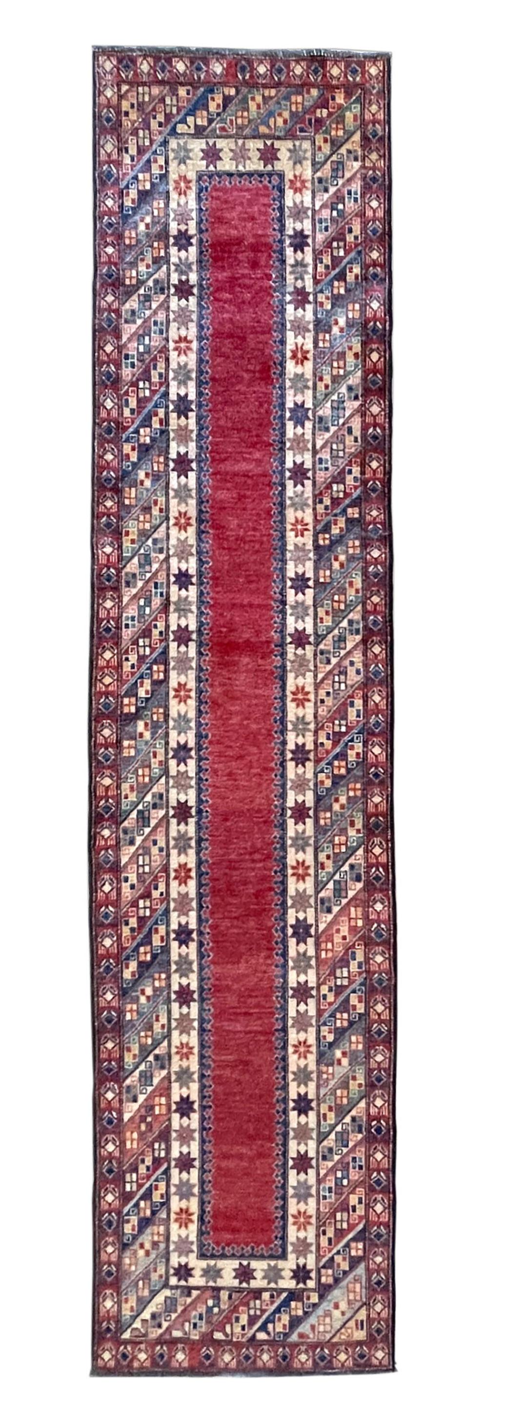 This tribal design runner rug is made in Pakistan, it has wool pile and cotton foundation. The base color is red and the border has multi colors. The design is geometric. The size is this piece is 2 feet 8 inch wide by 11 feet 11 inch tall. This is