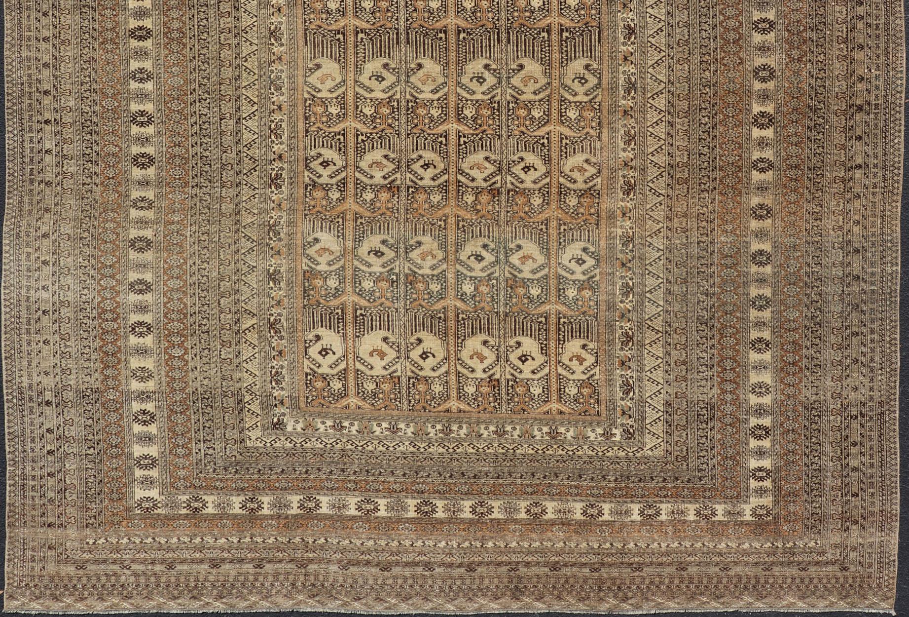 This Ersari rug has been hand-knotted in the finest wool. The rug features a repeating derivative of a tribal beluch design throughout the entirety of the rug, enclosed within a complementary, multi-tiered border, depicting small repeating tribal