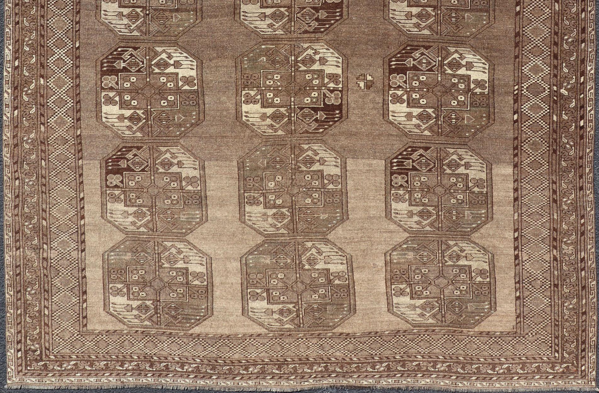This Ersari rug has been hand-knotted in the finest wool. The rug features a sub-geometric repeating Gul design throughout the entirety of the rug, enclosed within a complementary, multi-tiered border, rendered in small repeating motifs. The rug is