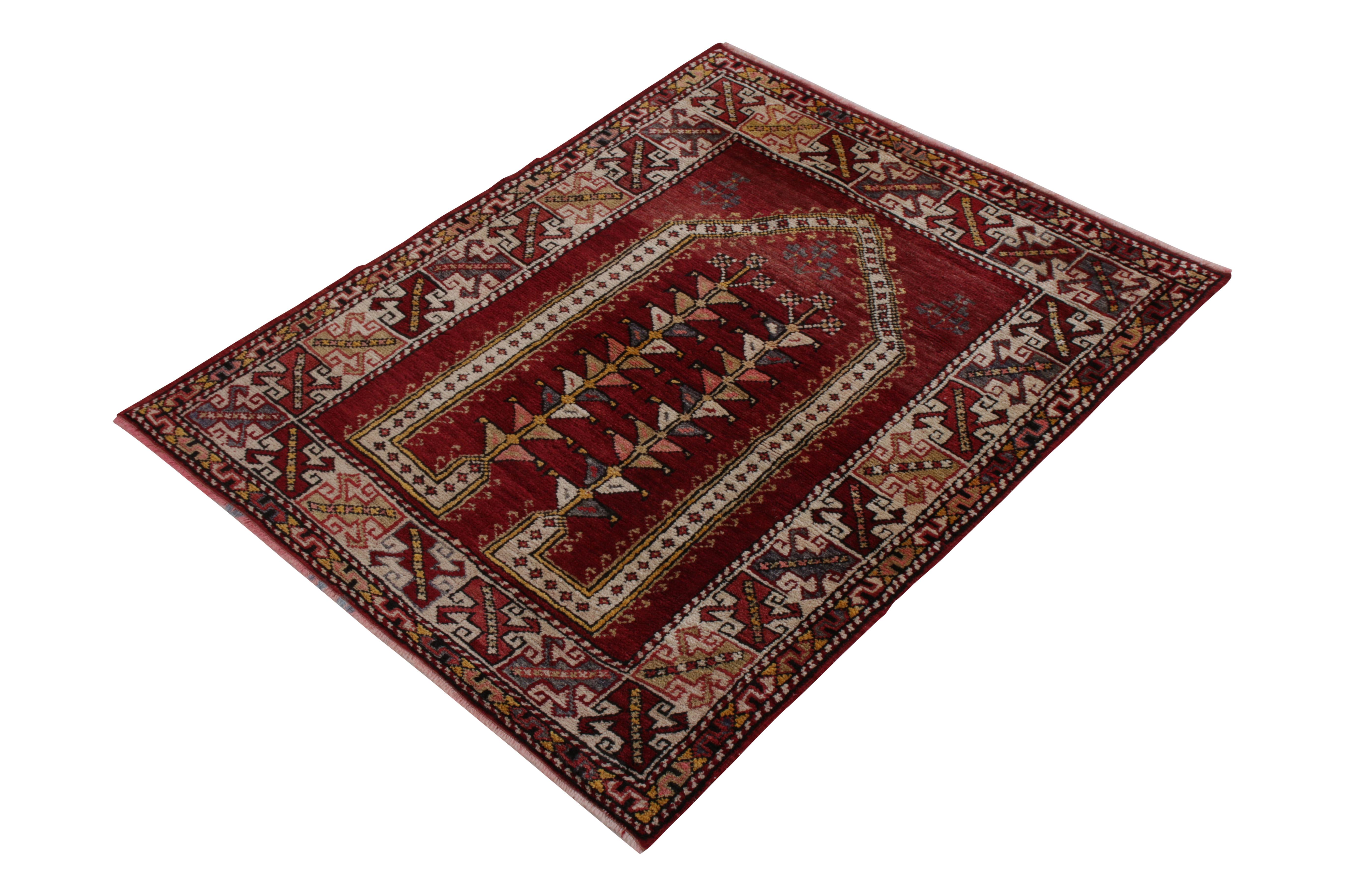 A 3 x 4 vintage rug of Ghiordes design, hand knotted in wool originating from Turkey, circa 1950-1960. Enjoying rich red and gold beside playful accents highlighting the classic mihrab pattern with movement and grace. In good condition for its age
