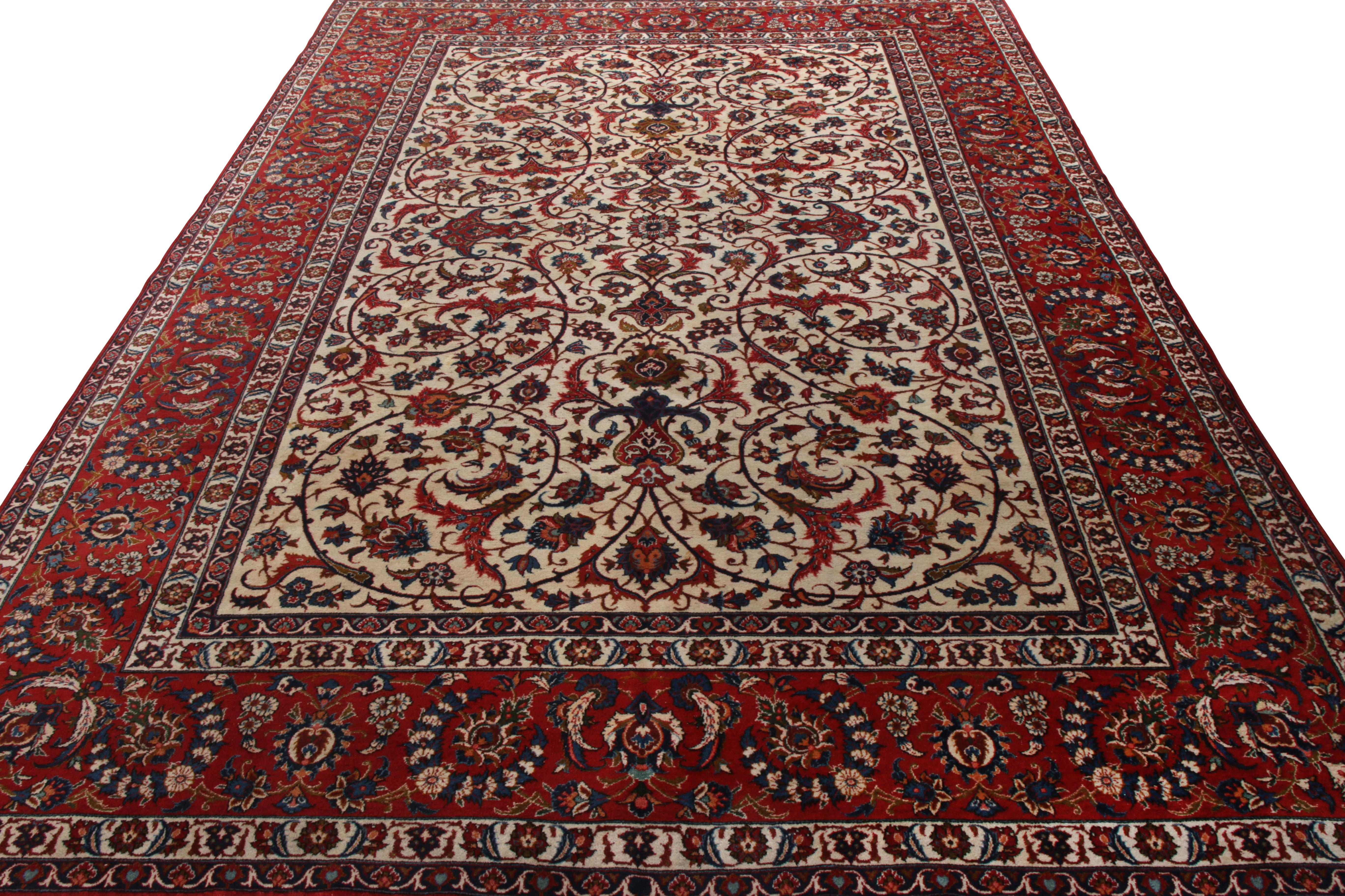Exemplifying the Persian aesthetic sensibilities of the 1950s, this hand-knotted 10x14 mid-century Isfahani rug joins Rug & Kilim’s Antique & Vintage collection. The rug witnesses a spectacle of floral patterns in rich hues of red and beige, with