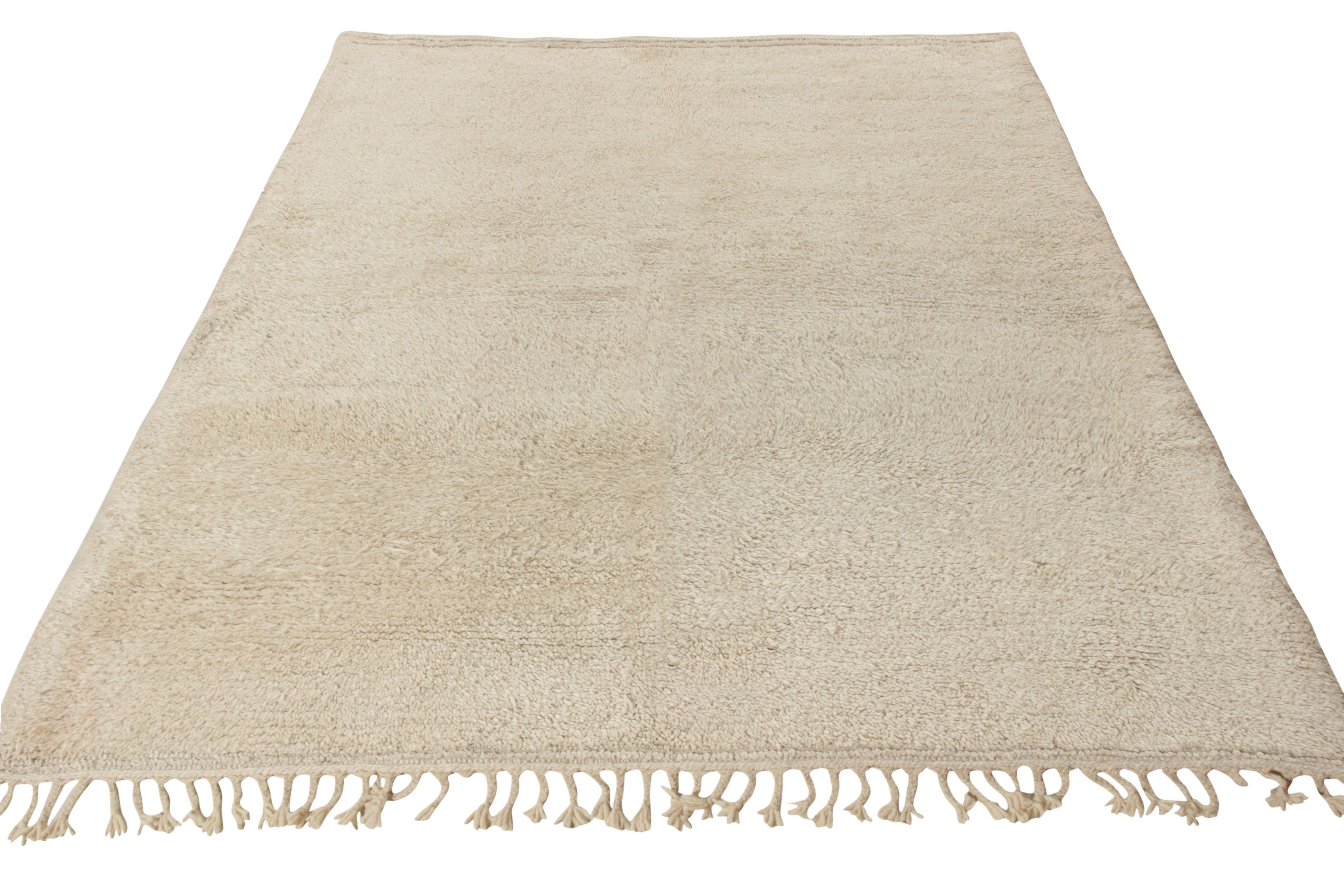 A 6x7 Berber style vintage Moroccan rug, hand knotted in wool circa 1950-1960. This luscious rug in tone-on-tone beige white spells a surreal vibe with its distinctive texture and design approach that carries a high-low weave on one end and fine