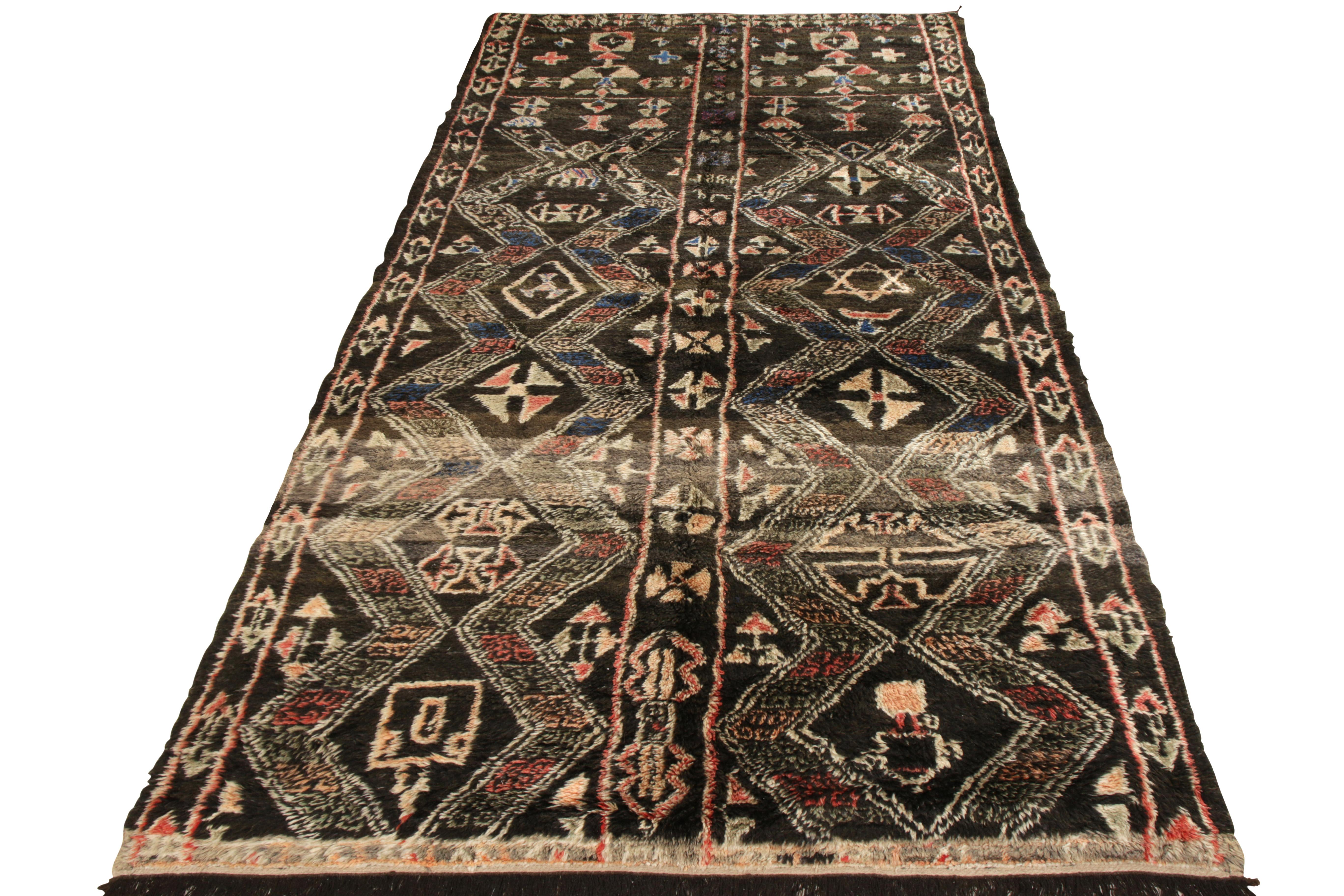 A 6 x 12 vintage Moroccan tribal rug, hand knotted in wool from Morocco circa 1950-1950. The rug comes from a strong community of Moroccan Jews who were rarely seen owning looms or making carpets, especially connoted in the intricate tribal pattern