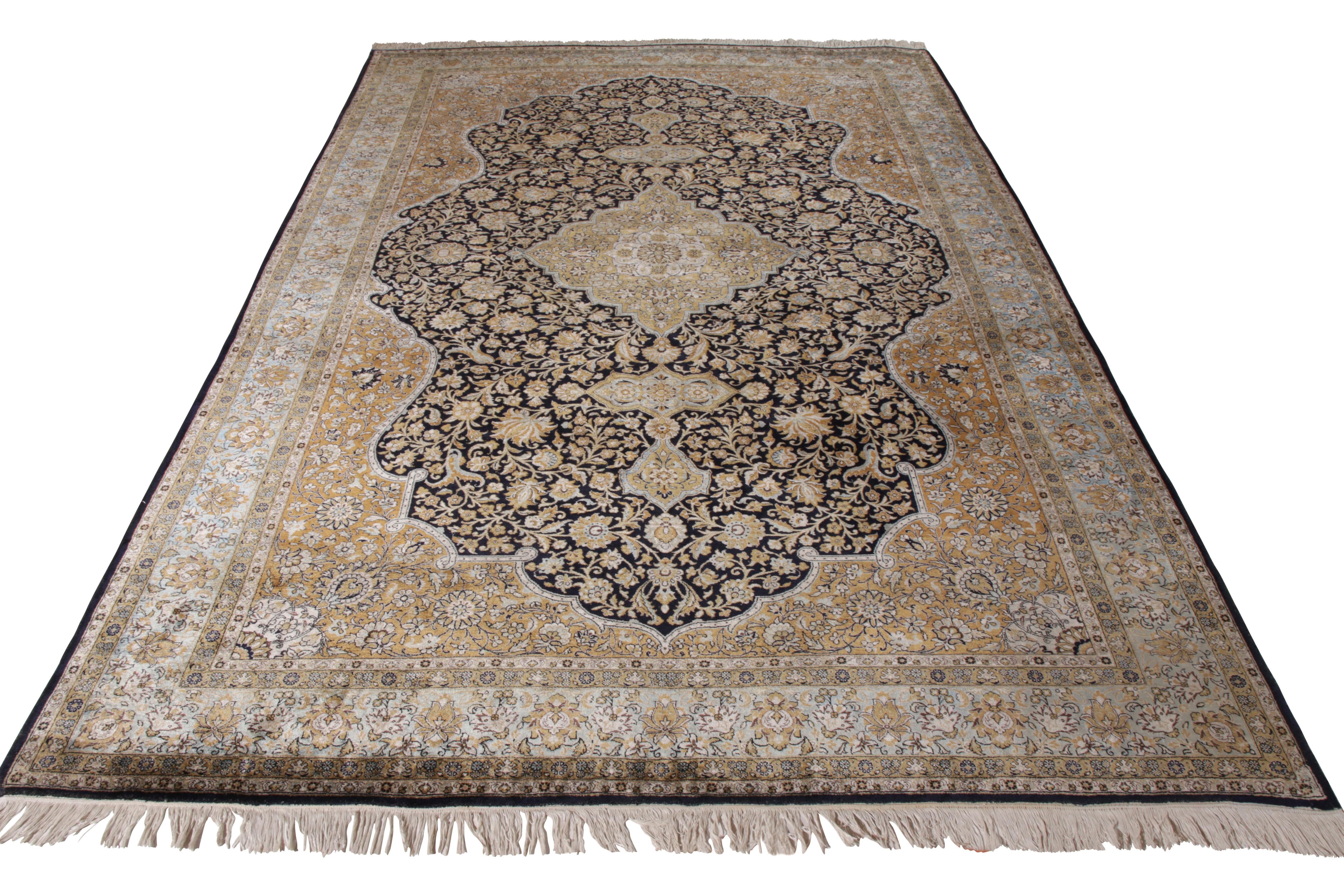 A 7x11 vintage Qum rug in regal medallion style, enjoying hues of beige-brown atop black with comfortable blue accents. Hand knotted in silk circa 1910-1920 from one of the most venerated mid-century Persian rugs among handmade Oriental rugs. 

On