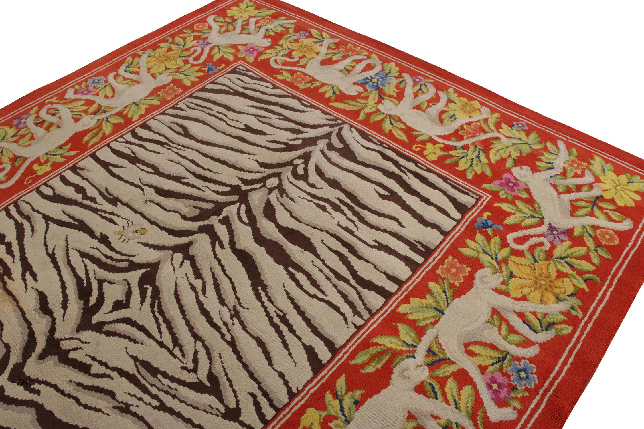 An 8x11 vintage rug in a rare mid-century pictorial design, hand-knotted in wool originating from Spain circa 1950-1960. Playing beige-brown Zebra-like stripes atop rich red in the most unique border, depicting finely detailed monkeys among graceful