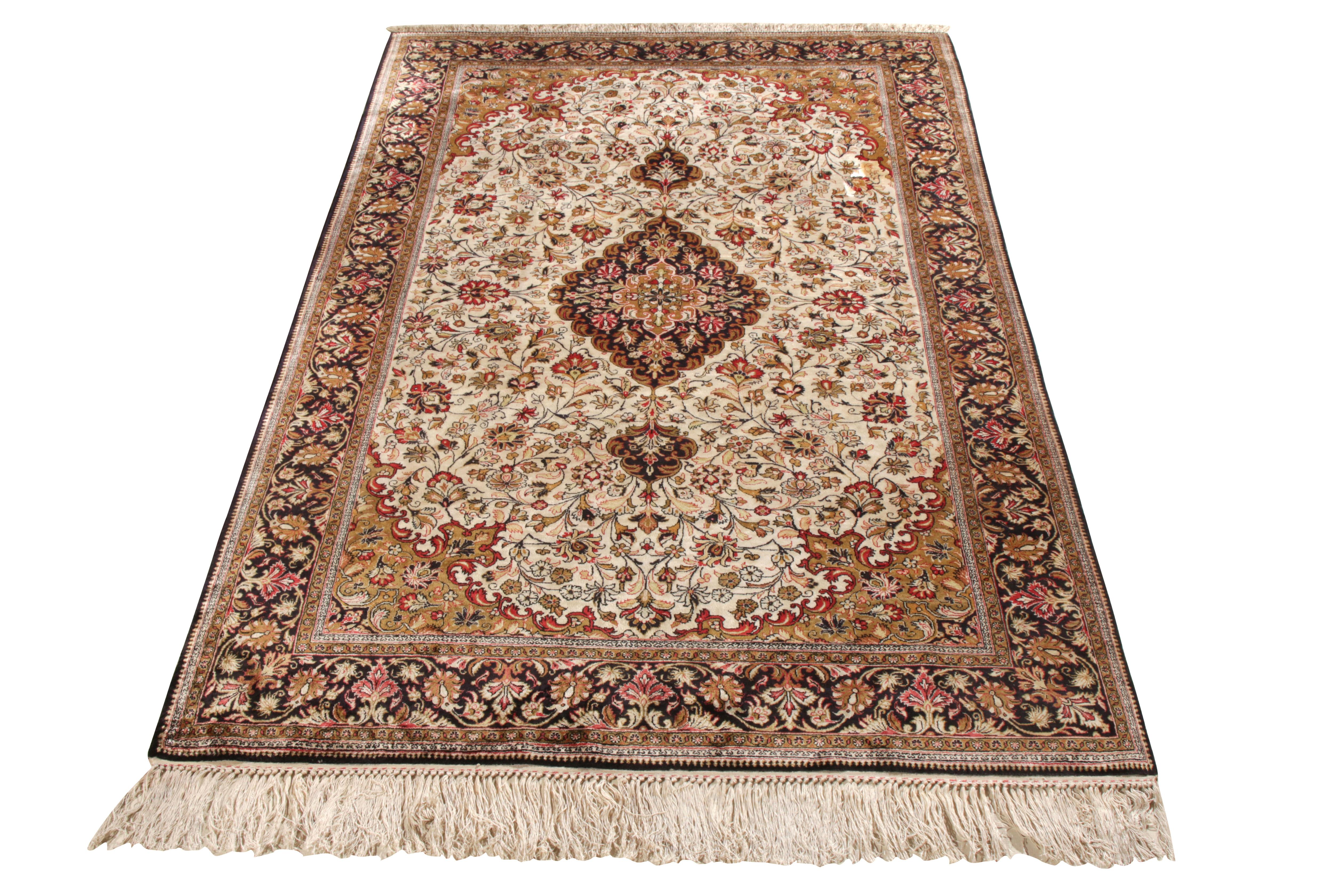 Emanating the fine craftsmanship of the 1950s, this hand-knotted mid-century Persian Qum rug makes way to Rug & Kilim’s Antique & Vintage collection. Characterised by a dense medallion and floral design embedded in a classy Black tone with muted