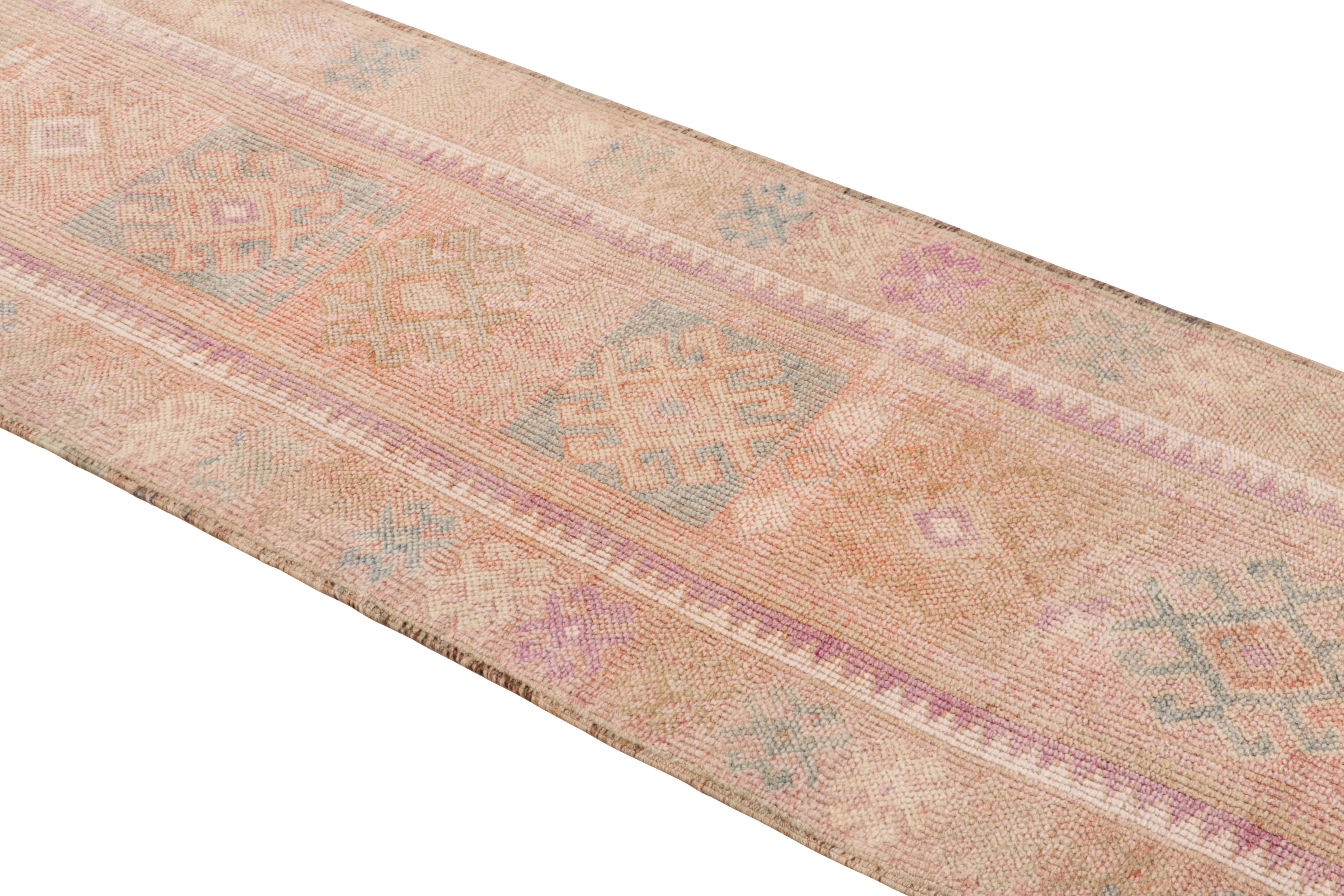 Dieser 3 x 12 große Läufer aus handgeknüpfter Wolle aus der Türkei (ca. 1950-1960) erinnert an ein Vintage-Stammesmuster von bemerkenswerter Größe, eine strukturierte Webart und eine unverwechselbare warme Farbgebung, bei der Orange- und Rosatöne