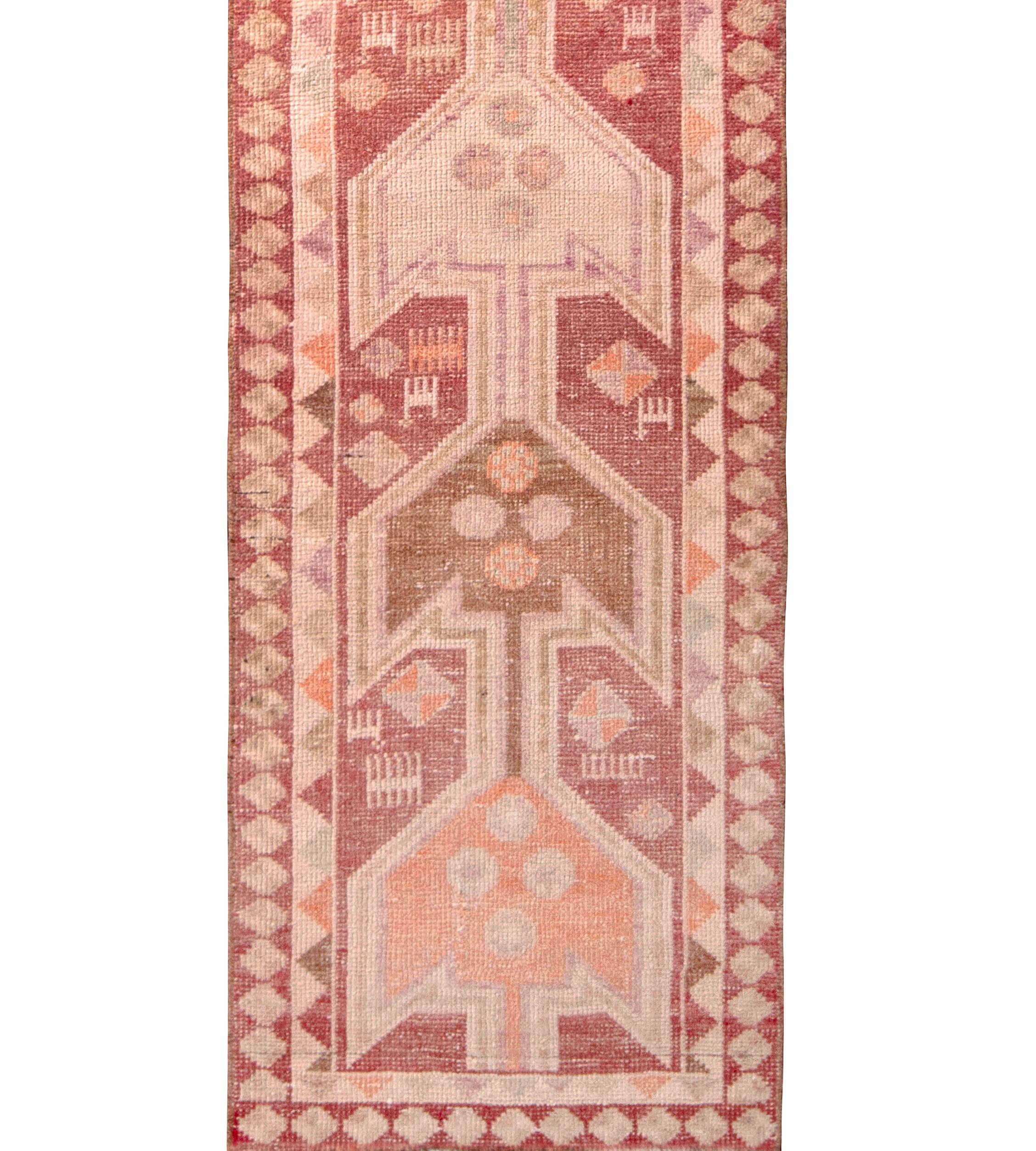 Hand knotted in wool originating from Turkey circa 1950-1960, this 3 x 11 runner connotes a vintage runner of both rich and playful color–a pallet of red and beige with lively transitional accents bringing out the tribal sense of movement this