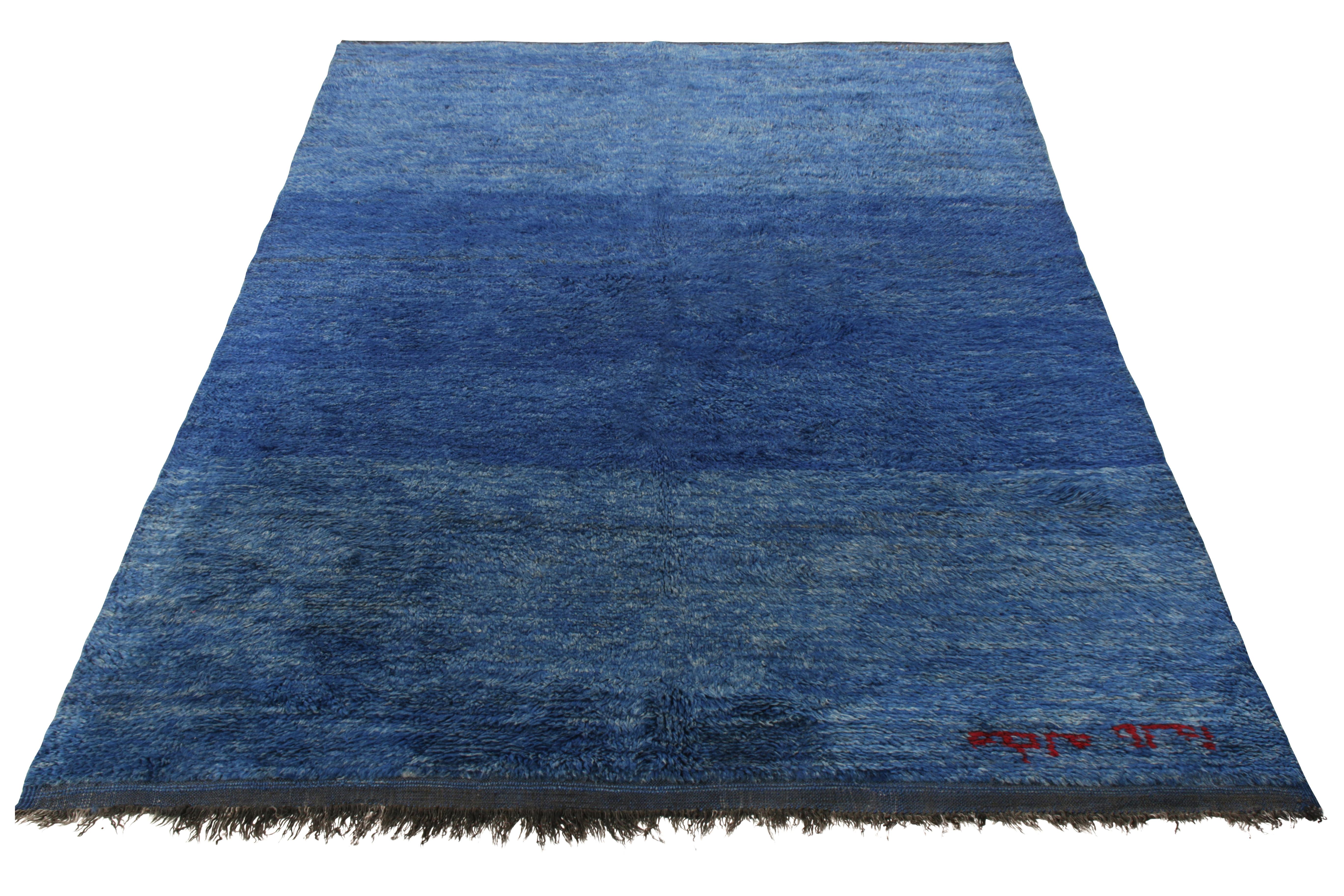 Hand knotted in wool from Morocco circa 1950-1960, this vintage 6x9 Moroccan Berber rug enjoys a luscious high pile in a soothing gradiance—playing tone-on-tone in shades of blue for a luxe take in such solid color tribal style. The rug further