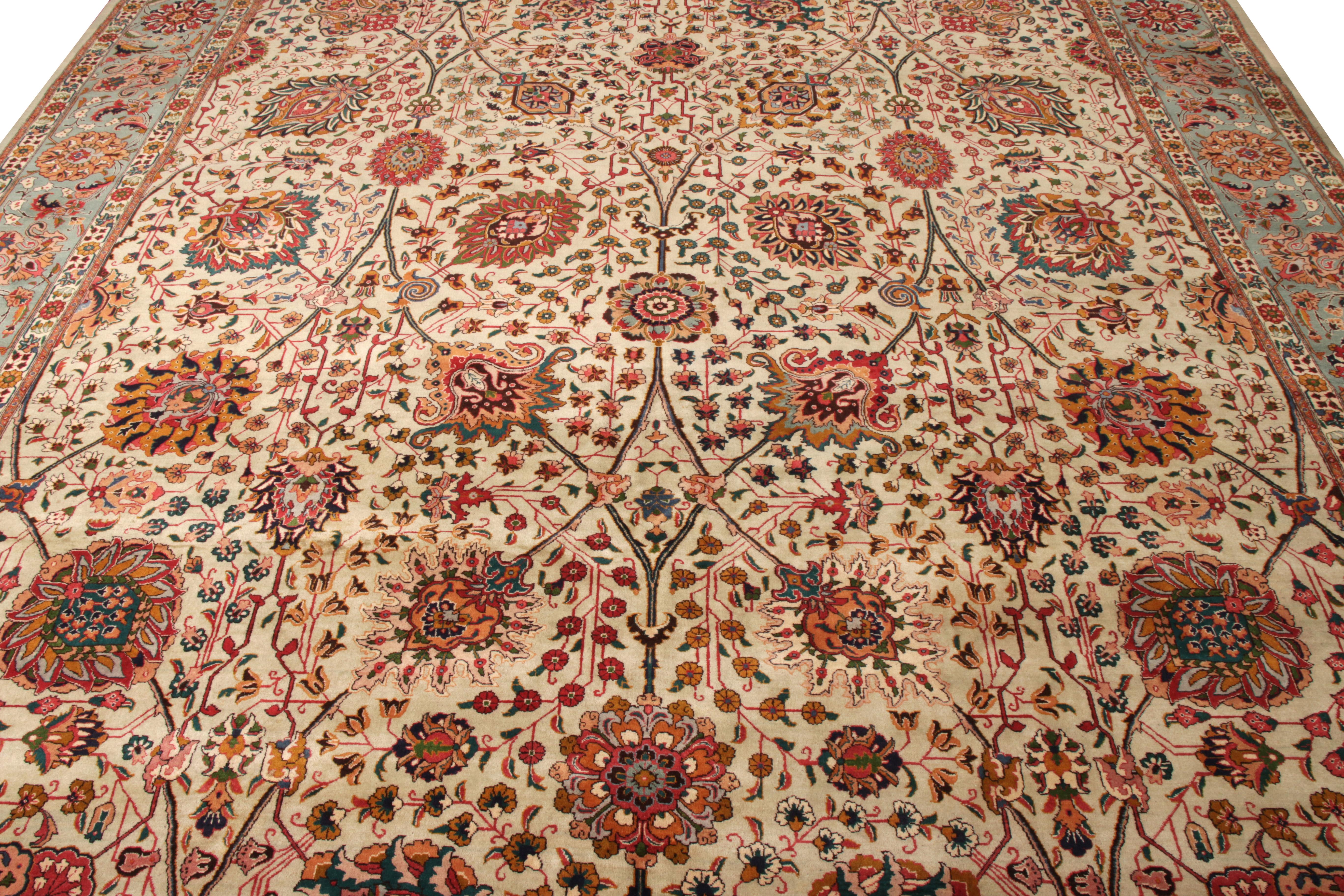 Hand knotted in wool circa 1950-1960, a vintage 11x14 Tabriz rug enjoying a dense floral pattern in a spectrum of lively hues sitting majestically on a beige background for an opulent look. The tasteful employment of green-blue in the border ending