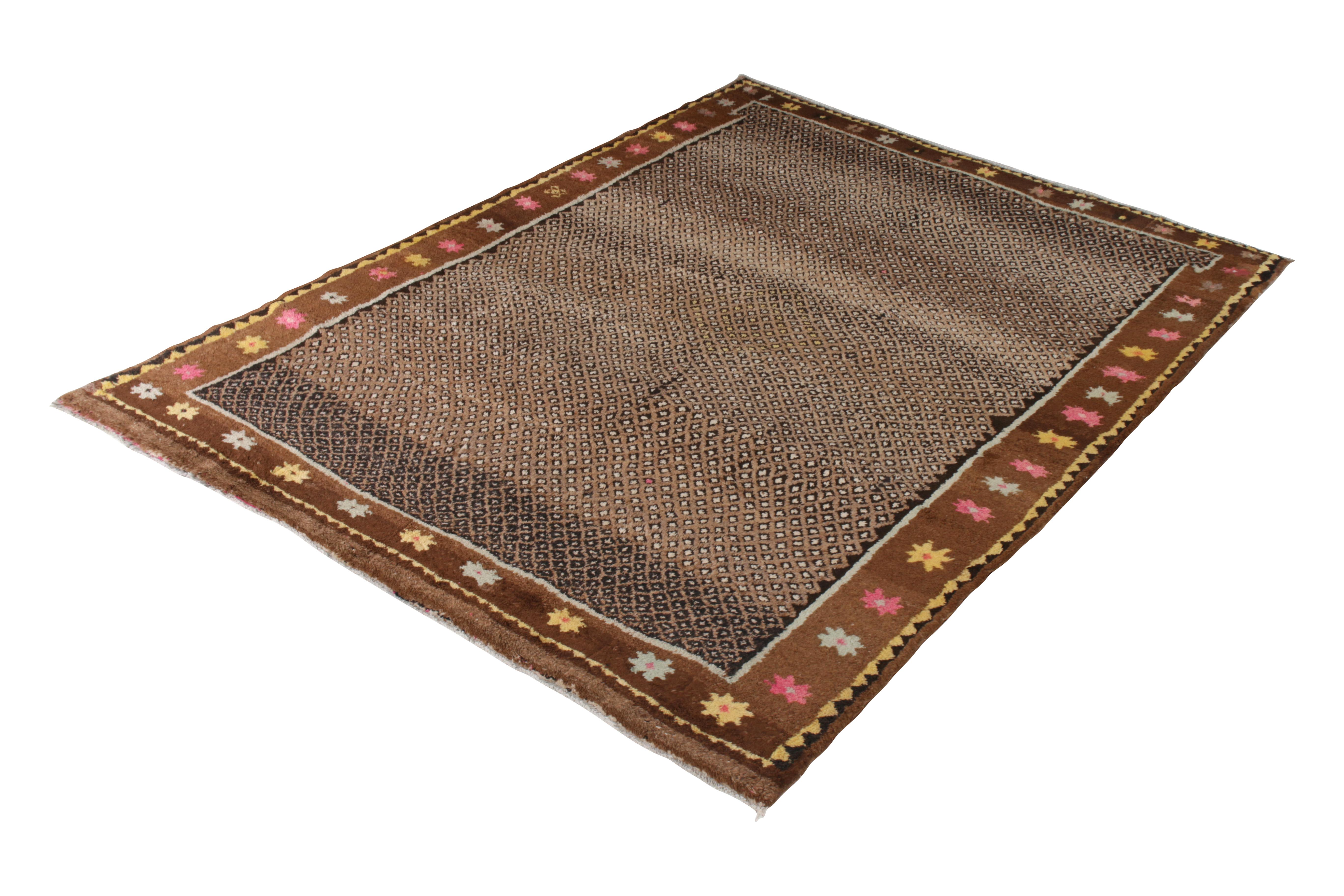 Hand knotted in a lush wool pile originating from Turkey, circa 1950-1950, this 9 x 11 vintage rug of midcentury Turkish origin enjoys rich play of beige-brown with whimsical accents in the star motifs meandering through the border. These elements