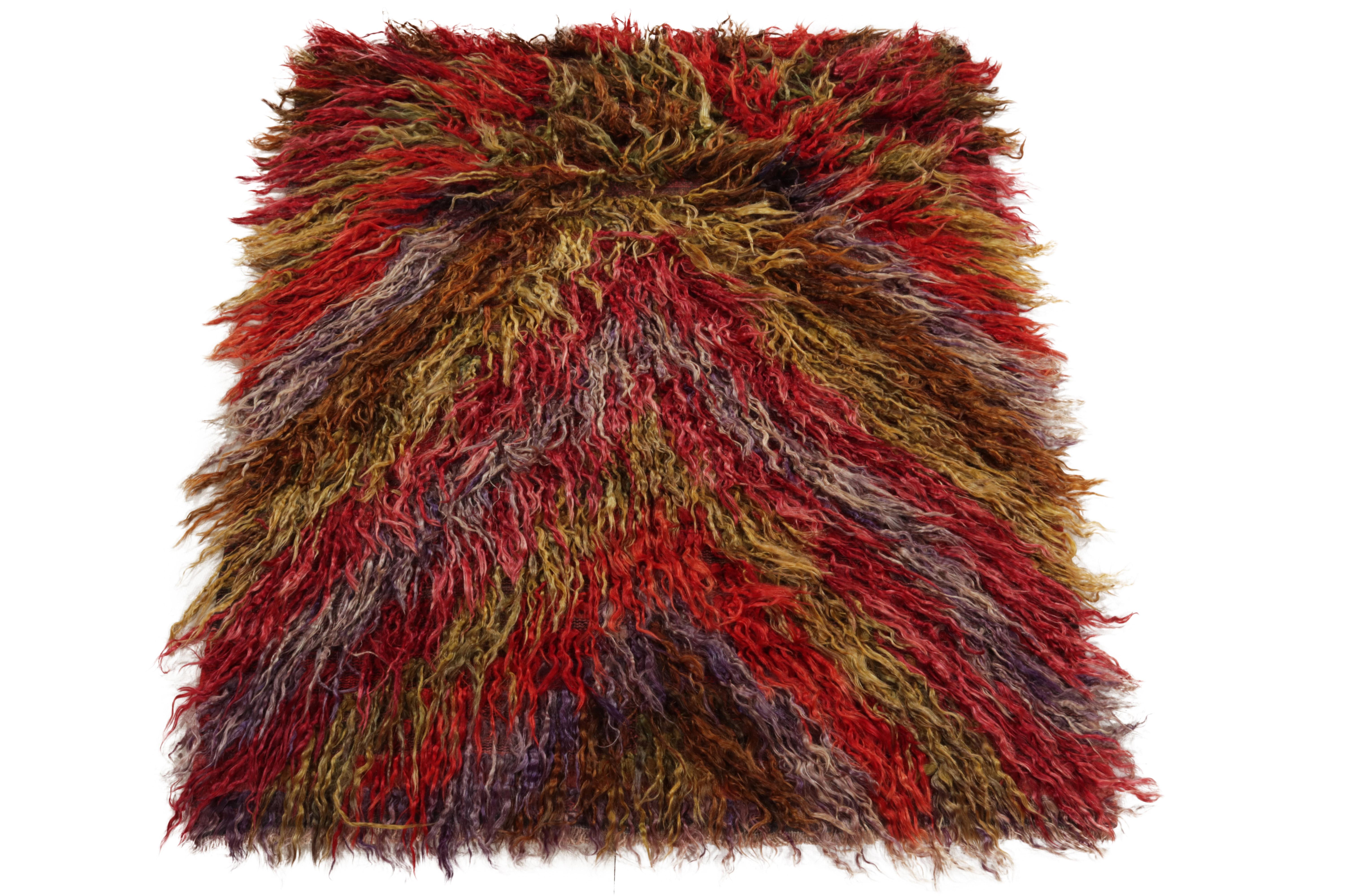 From Rug & Kilim’s tribal selections, a hand-knotted vintage Tulu rug carrying a luscious high pile. Originating from Turkey circa 1950-1960, the rug enjoys a geometric pattern in hues of red, brown & ink blue further complementing the shaggy