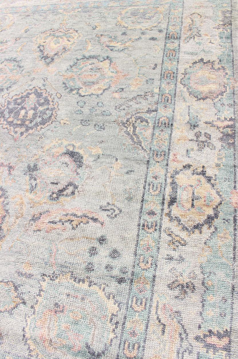 Hand Knotted Wool Oushak Rug Featuring Floral Designs in Muted Colors 7'8