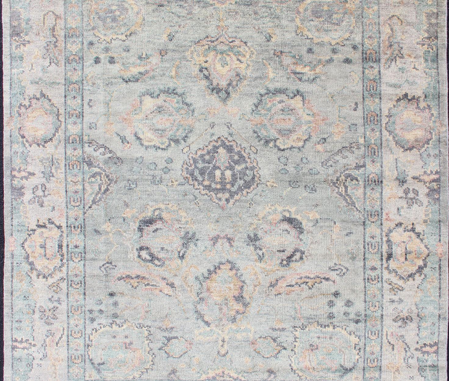 Hand Knotted Wool Oushak Rug Featuring Floral Designs in Muted Colors 7'8