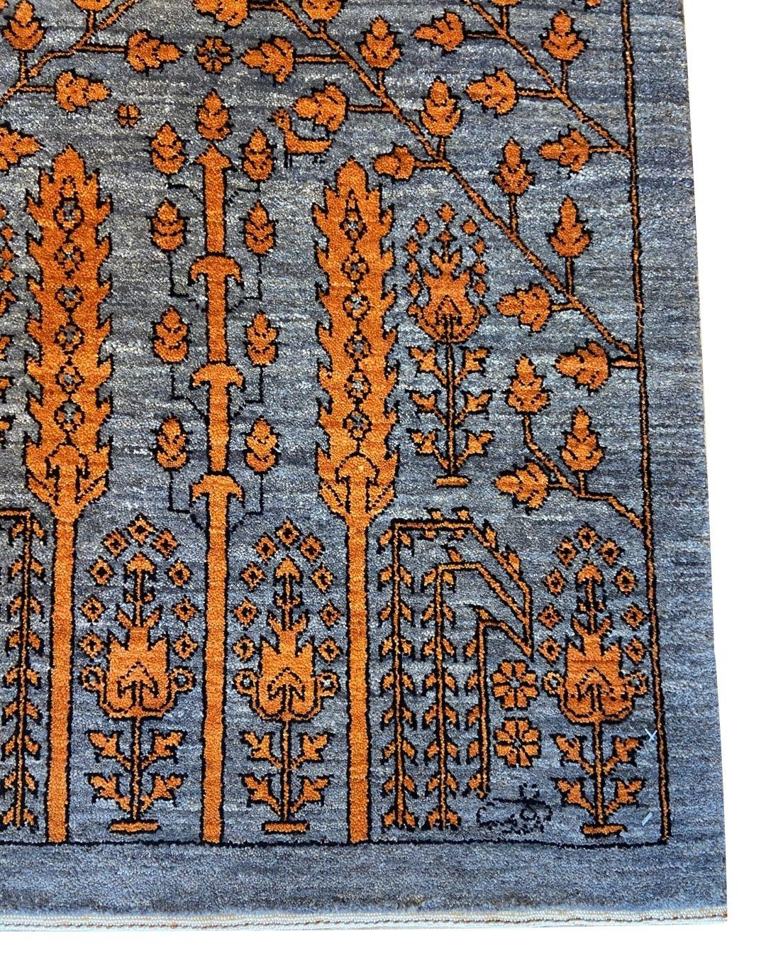 Dieser handgeknüpfte 4' x 6' große Wollteppich mit architektonischem Blumenmuster in Grau und Orange verwandelt Jahrhunderte persischer architektonischer Inspiration in ein auffälliges zeitgenössisches Textil. Mit seinen stilisierten hängenden