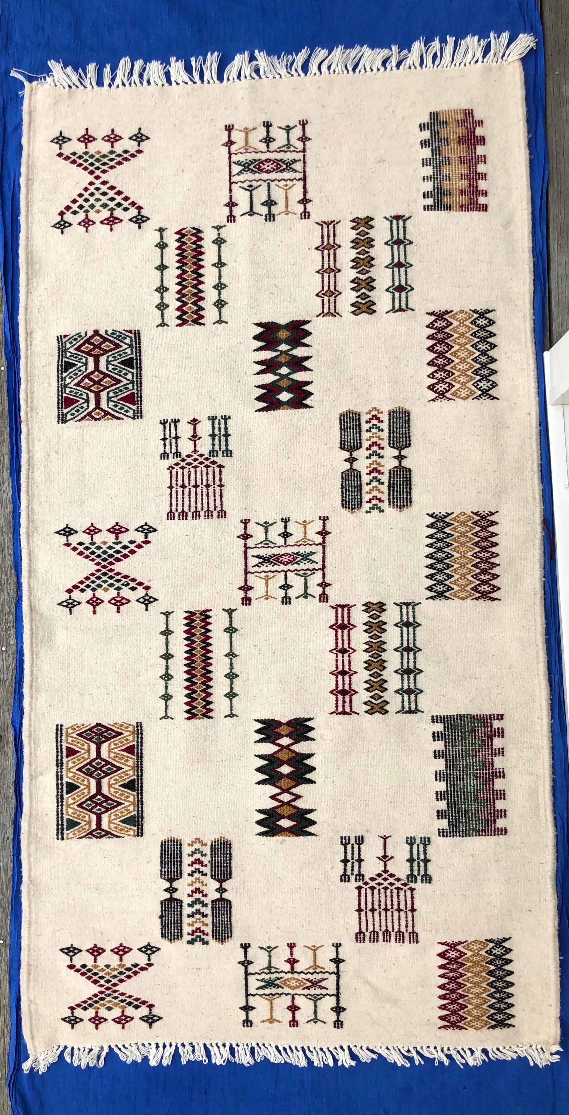 This gorgeous rug is hand-loomed from 100% sheep's wool and pearl cotton fibers. Berber use them in multi purposes on floor, hang them on wall as art or put on sofa. The symbols on this rug represent the combs used to clean the wool, 
as well as