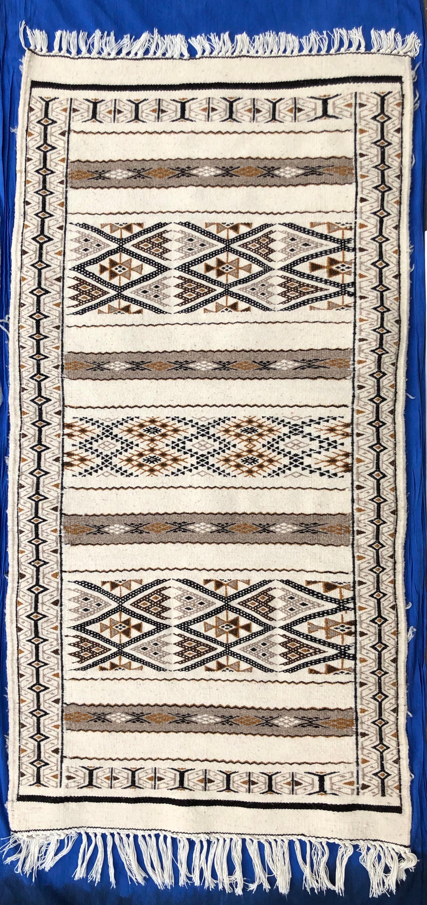 This gorgeous rug is hand-loomed from 100% sheep's wool and pearl cotton fibers. Berber use them in multi purposes on floor, hang them on wall as art or put on sofa. This rug is replete with symbols representing the evil eye (protection), fertility,