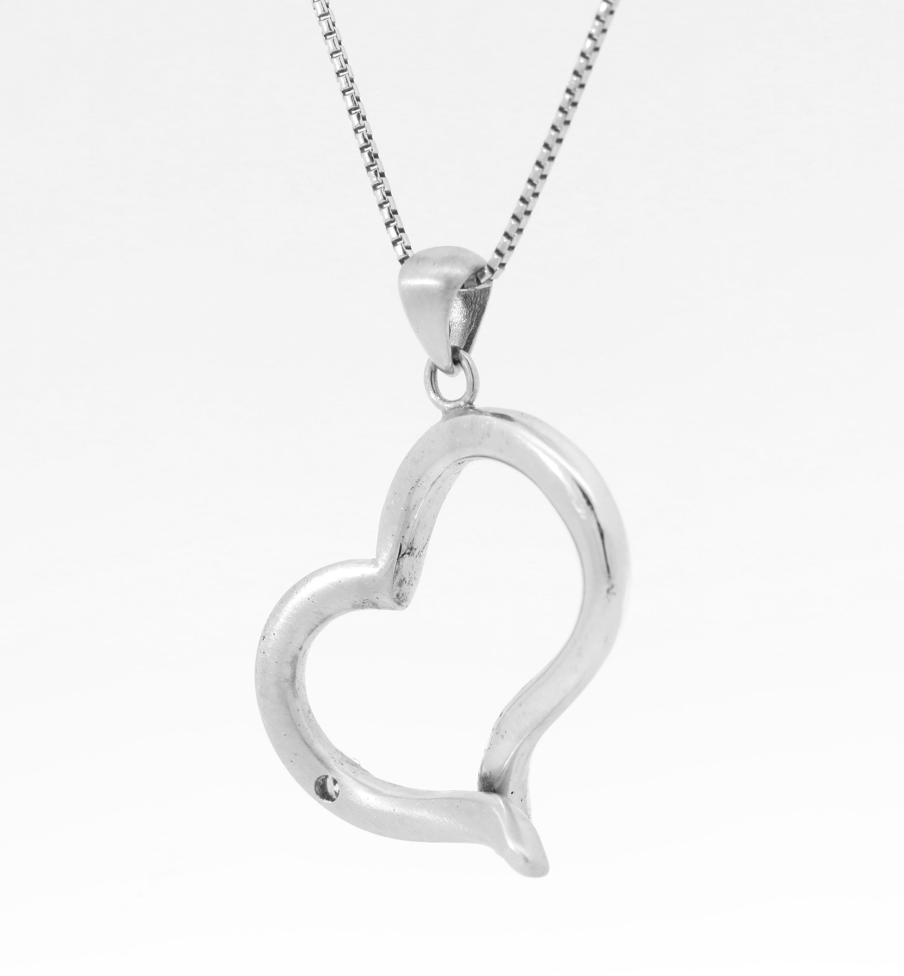 Collana a forma di cuore con diamanti naturali, realizzata a mano in oro bianco 14K.
Peso totale: 4,4 grammi. 
Diamanti: 0,10ct. 
Nota bene: la catena non è inclusa.