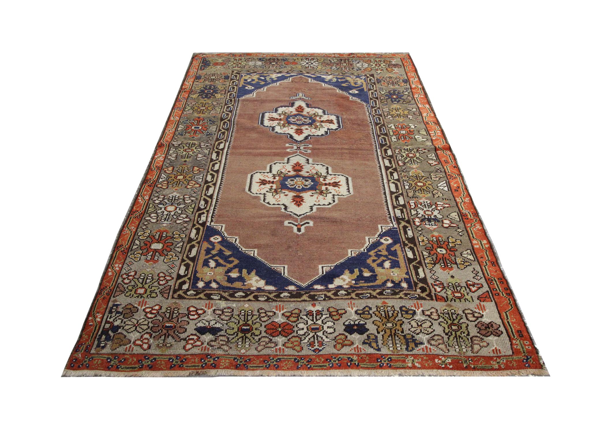 This high-quality Antique Turkish rug was handwoven in 1930 with hand-spun, vegetable-dyed wool, and cotton, by some of the finest Caucasian artisans. Featuring two central emblems, intricately woven with floral patterns on an orange background.