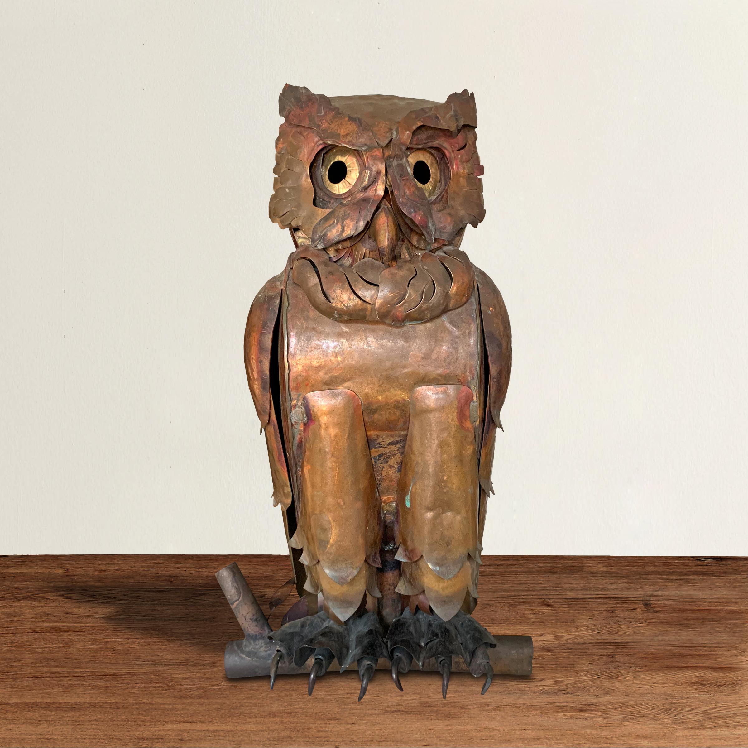 A whimsical and folky handmade copper owl with an expressive face with large brass eyes, copper feathers, and iron talons, resting a copper tube “tree branch.” It’s possible this was made as part of a weather vane.
