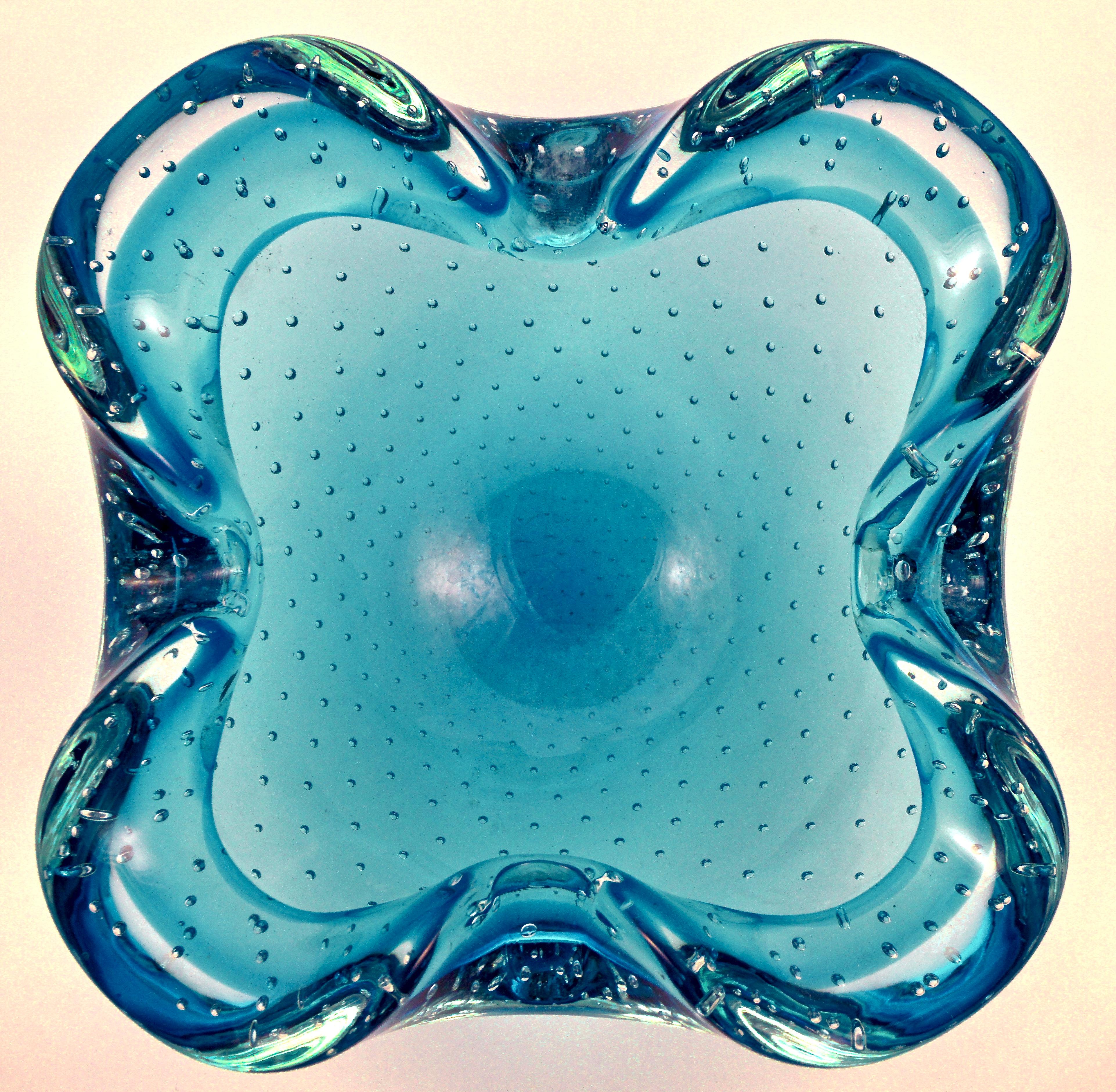 Hand made art glass ashtray in an electric blue and clear colourway, featuring controlled bubbles. The ashtray has a lovely curved organic shape. It is in very good condition, with some scratching, and measures width 17.2cm / 6.77 inches.

This is a