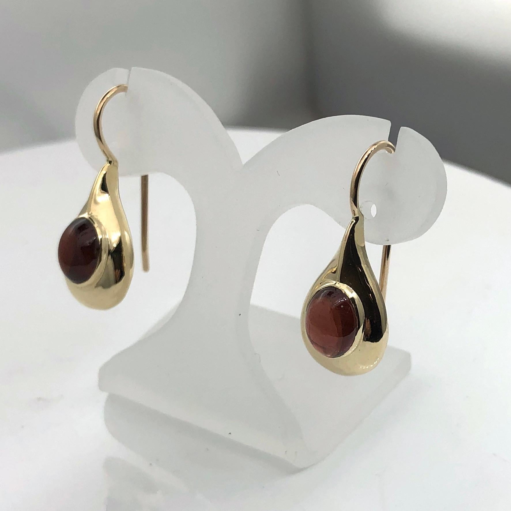 Elegant and beatifully crafted by hand  tear drop earrings in classic Art deco style
Made of 9 carat yellow gold and set with oval light red Garnet
Stone measurements are 6mm x 8 mm
Drop wire is secured by a safety clip
Earring length is 27 mm,