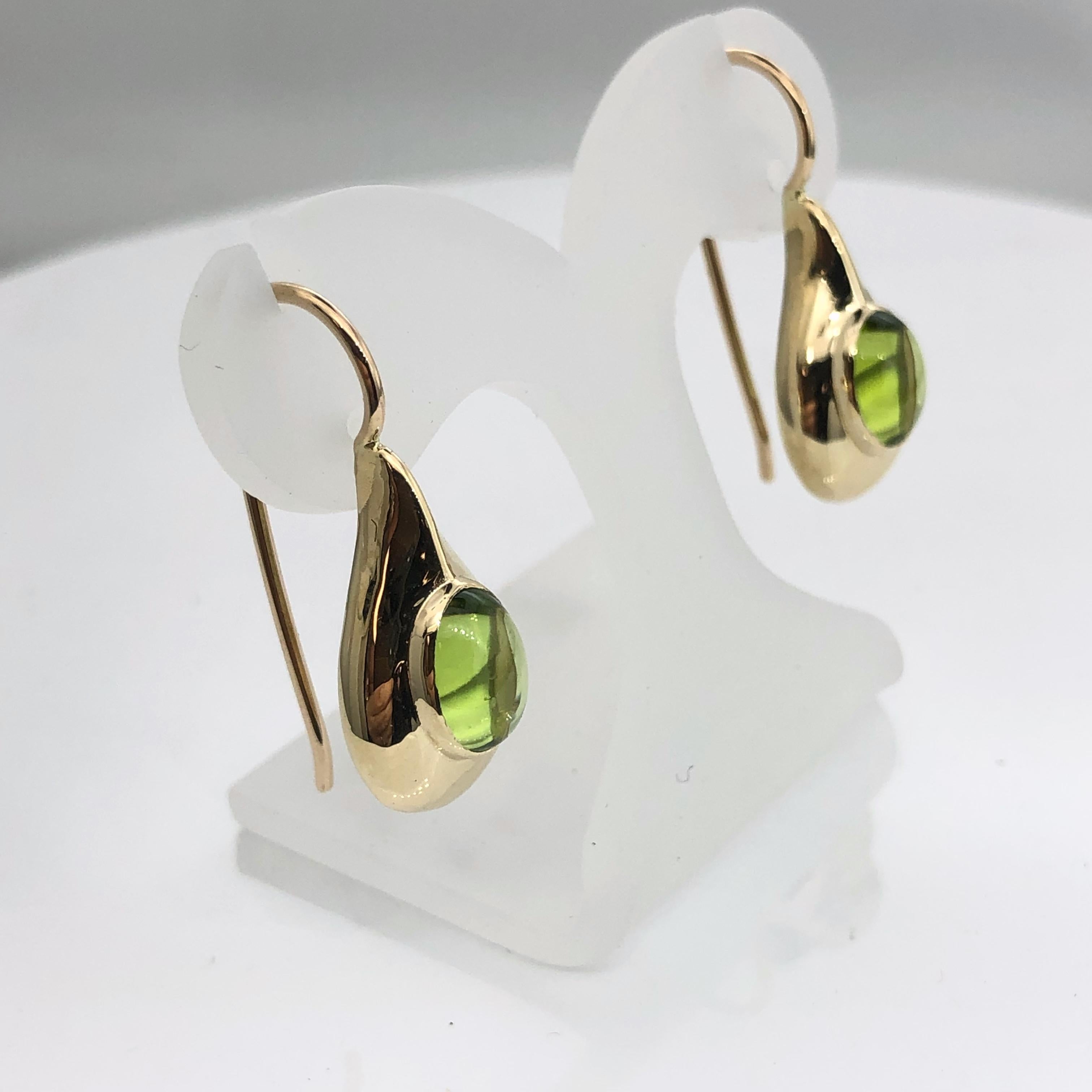 Elegant and beatifully crafted by hand  tear drop earrings in classic Art deco style
Made of 9 carat yellow gold and set with oval cabochon cut peridot 
Stone measurements are 6mm x 8 mm
Drop wire is secured by a safety clip
Earring length is 27 mm,