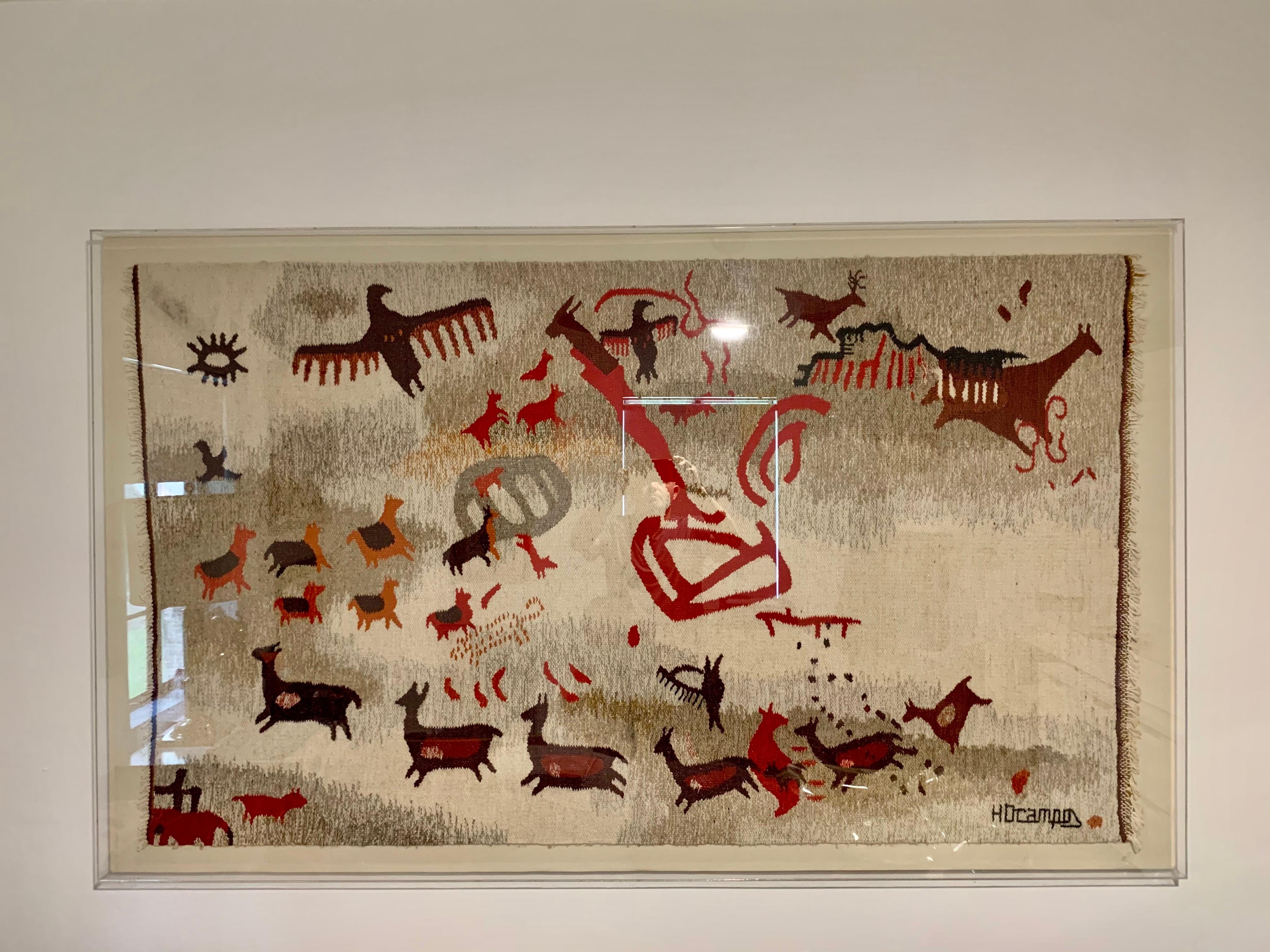 This shadow box all acrylic framed handwoven wool rug with rich and vibrant colors. This is a Signed piece by H. Ocampos, renowned for his technique and mastery of indigenous scenes from Argentina's North country.
