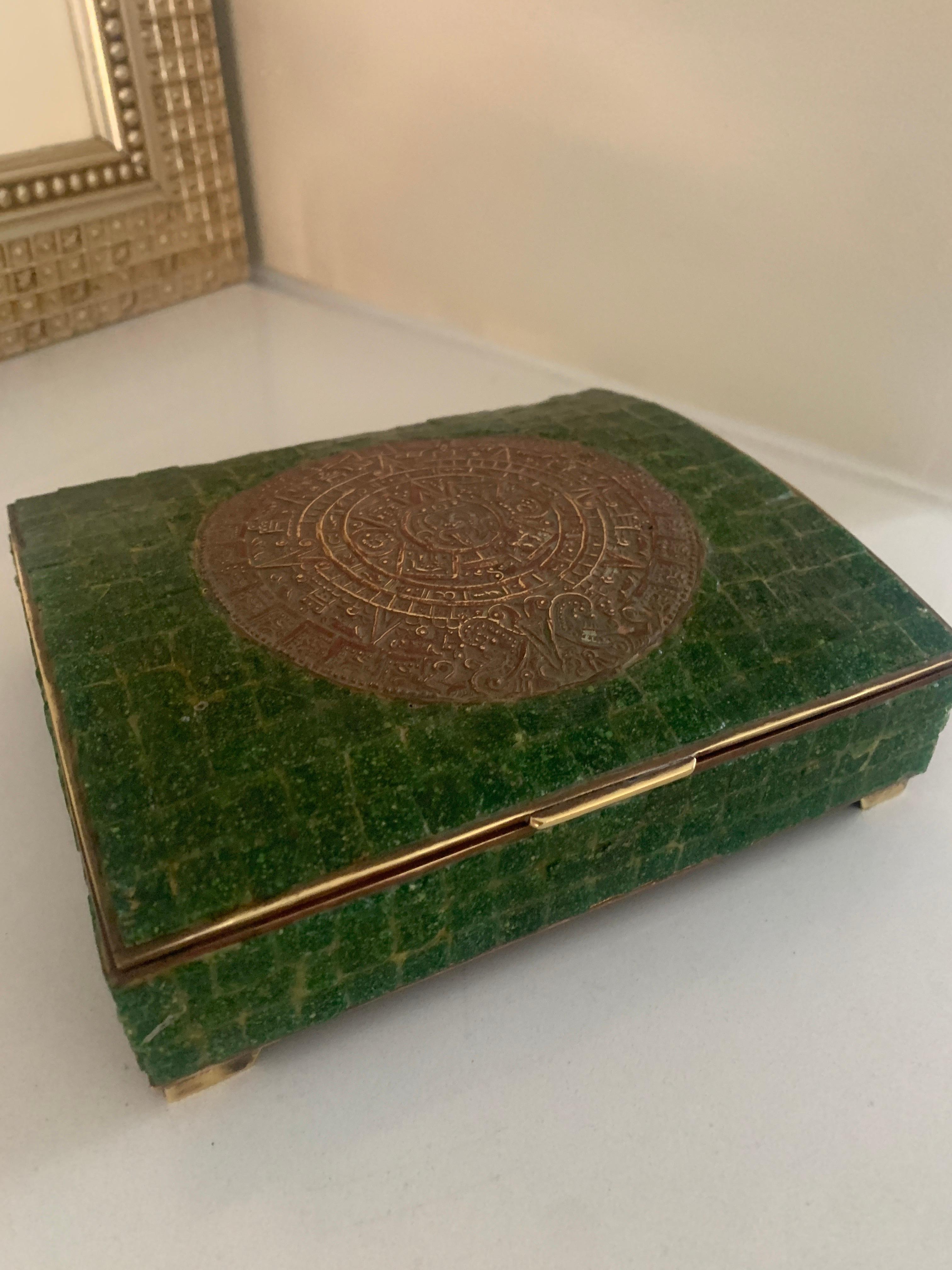 Hand made Mexican brass and stone box with medallion - in the style of Los Castillo or Pepe Mendoza.

The brass box is lined in wood with exterior tiled green stone and brass inlayed Aztec Calendar. Most likely a cigarette box, however suitable
