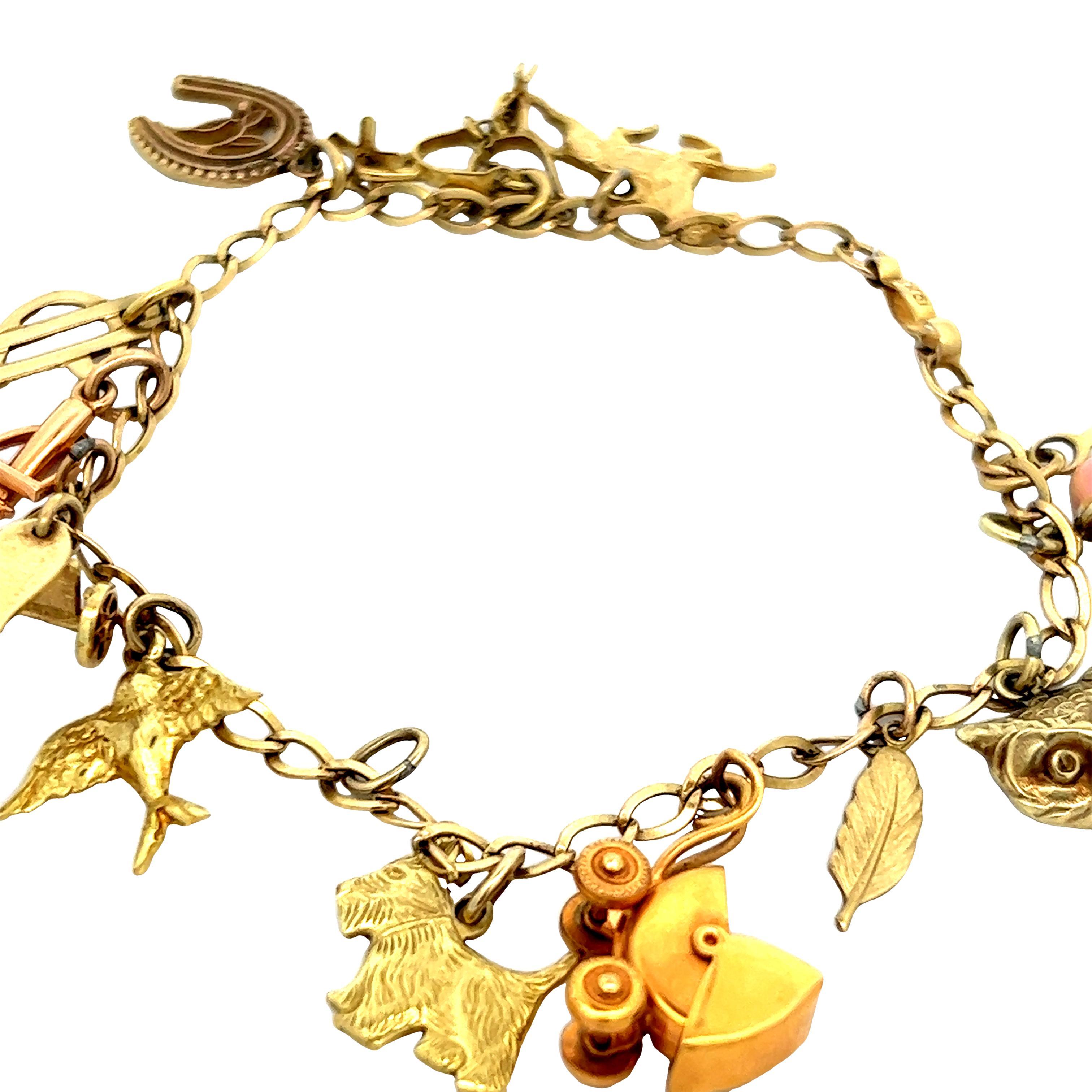 Questo braccialetto di ciondoli mobili fatto a mano risale agli anni '50 e presenta 14 charme in oro giallo 10k. Questo braccialetto è molto divertente grazie all'assortimento di charme, la maggior parte dei quali riguarda gli animali o la Nature.