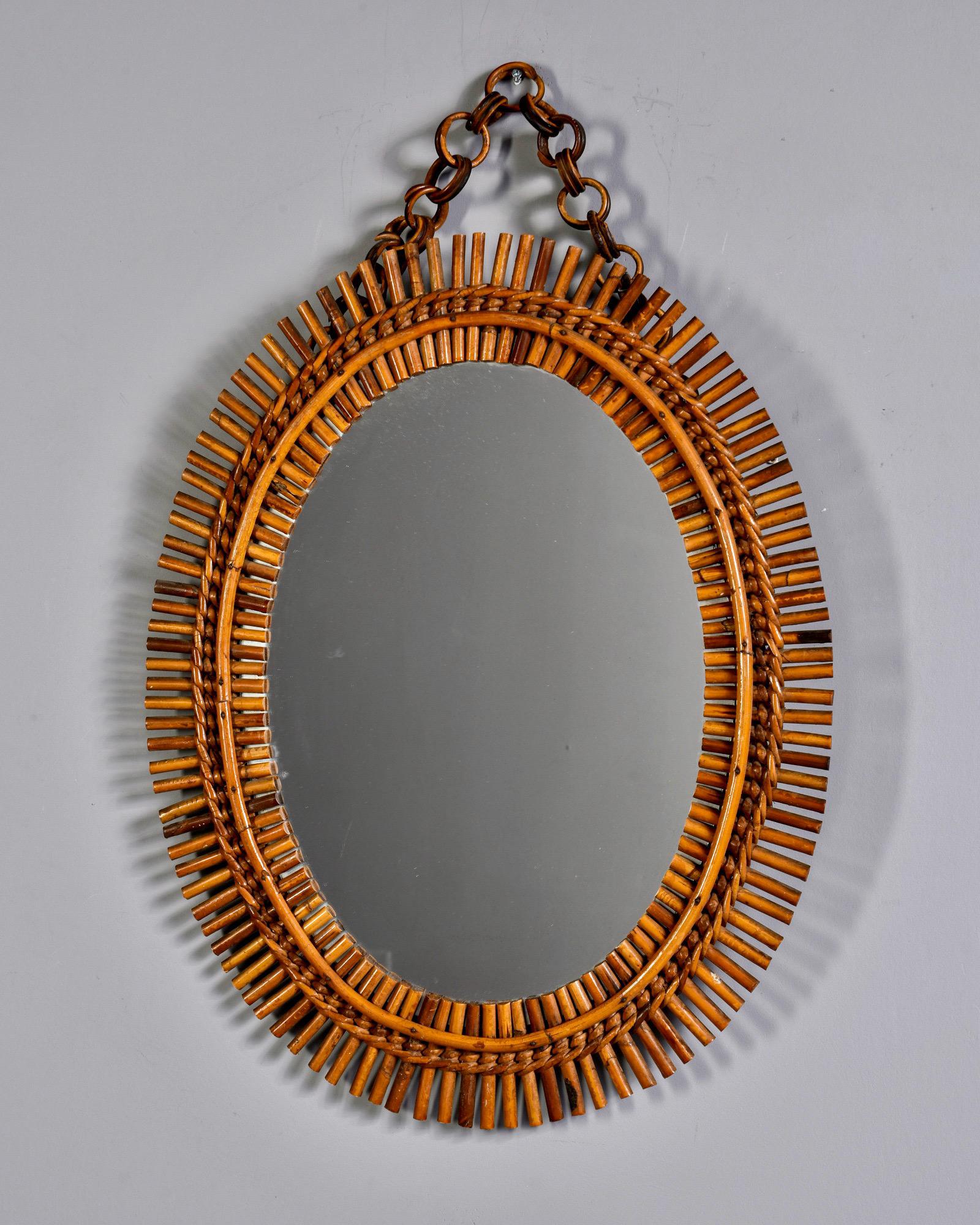 Circa 1970s oval mirror with hand made rattan frame and metal hanging chain. Unknown maker. Found in France. 

Actual mirror size: 16.25” H x 11.25” W
Hanging height: 27.5” includes chain.