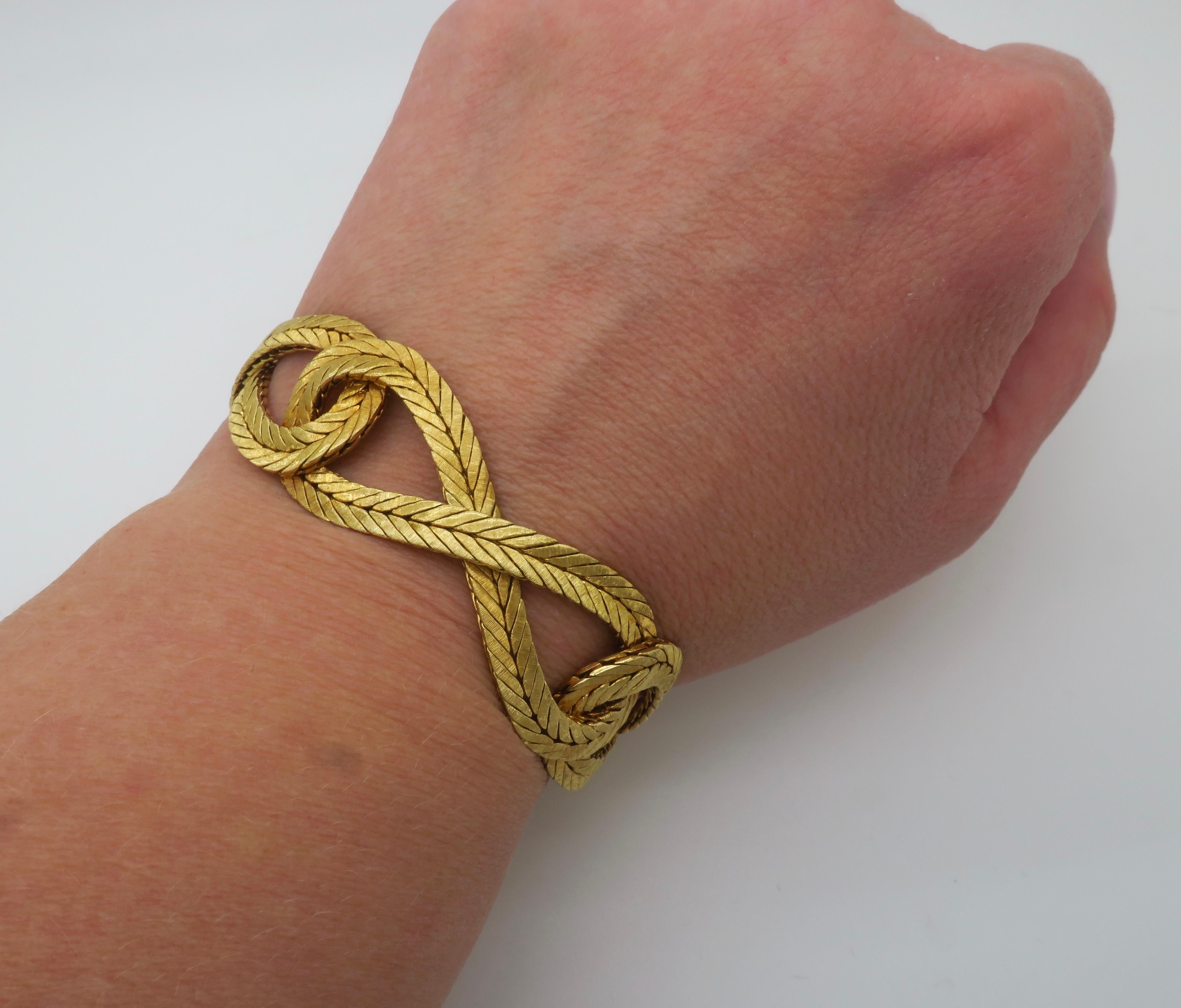 Bracciale in oro 18 carati intrecciato, realizzato a mano, firmato e numerato, con finitura spazzolata e catena di sicurezza. 

Metallo: oro giallo 18k 
Timbro: 