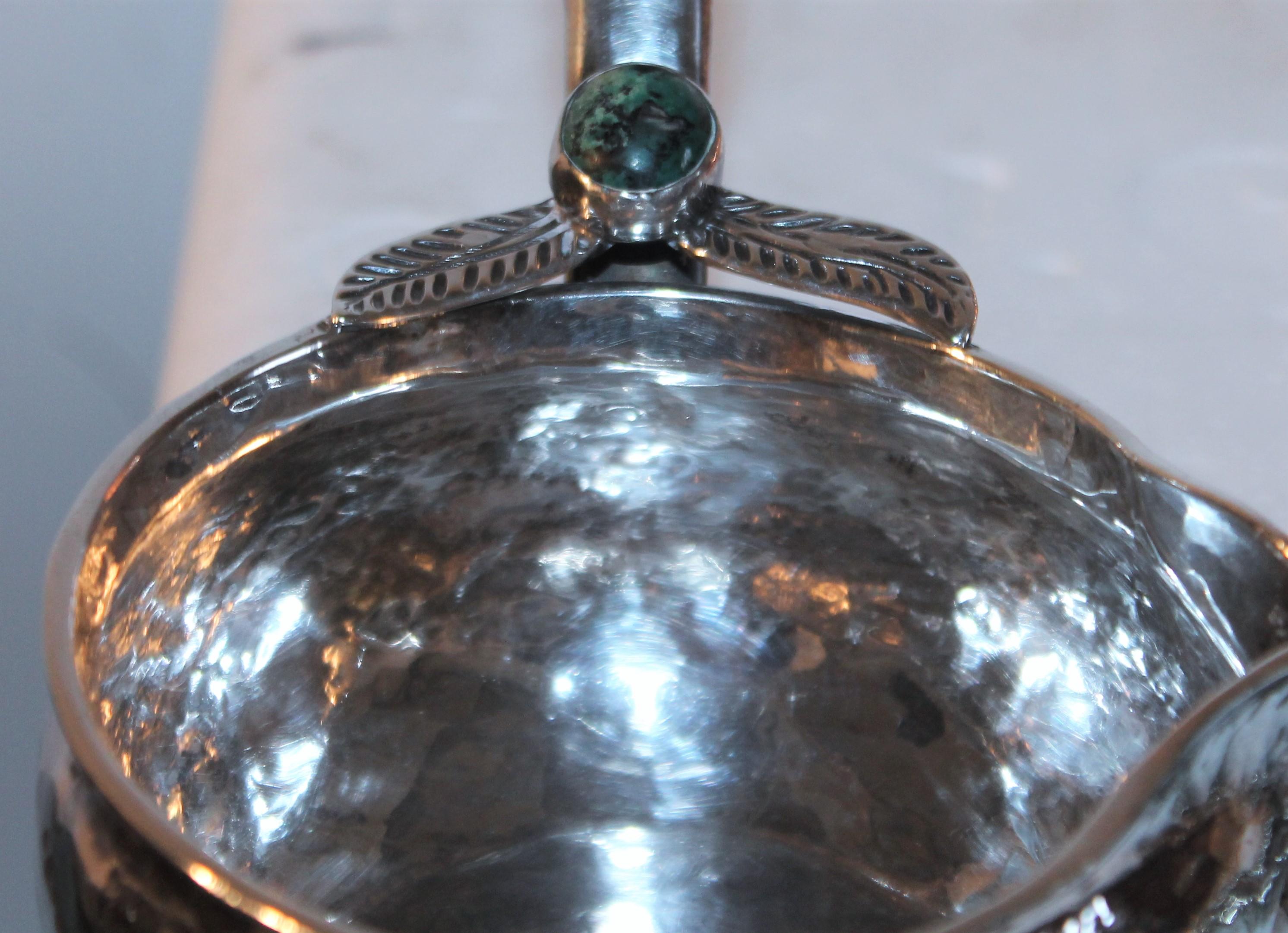 This fantastic sterling silver handmade ladle or dipper has a nugget of turquoise and a hand carved teak handle. The condition is fantastic. Such great workmanship. Marked 925 & Peru.